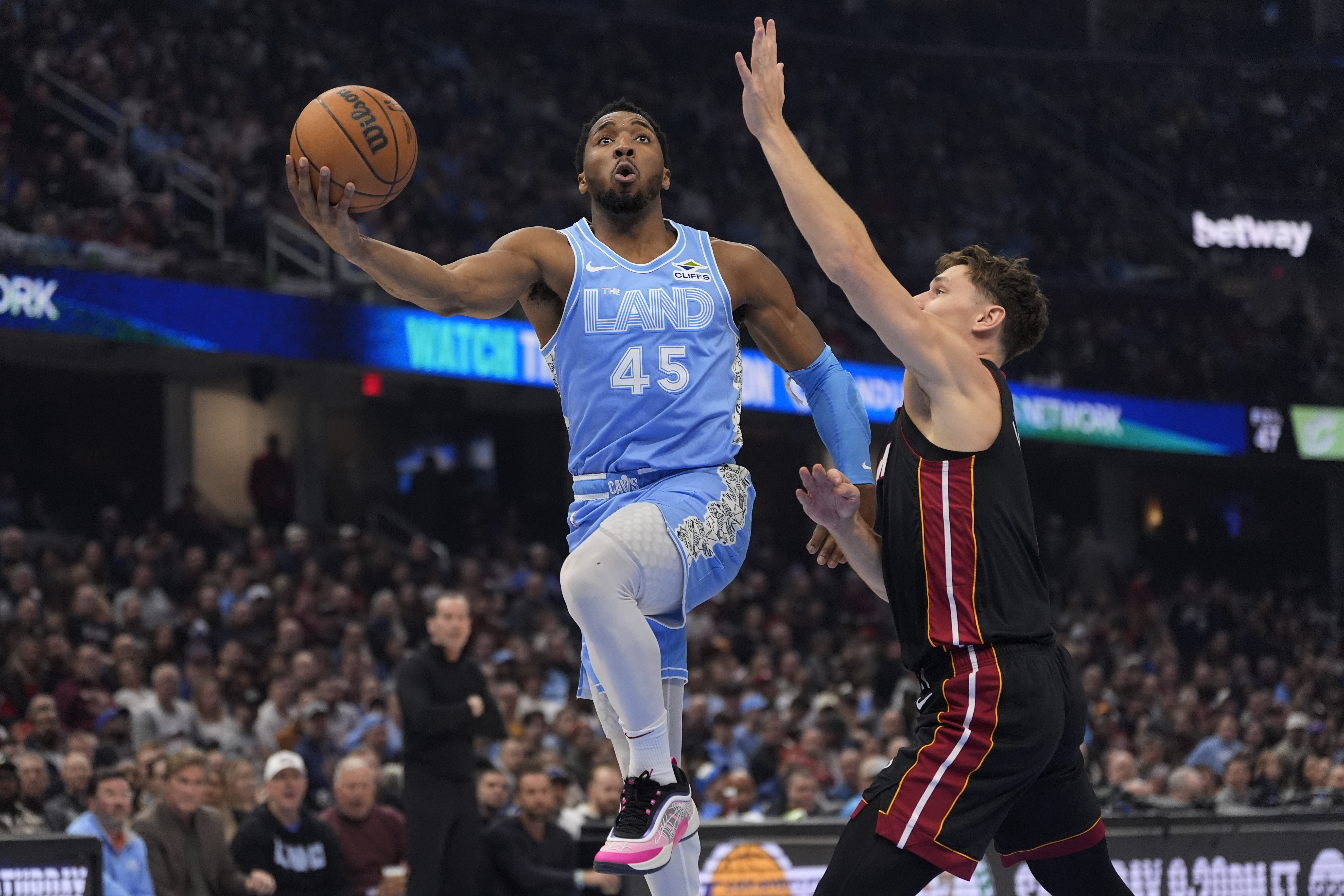 Cleveland Cavaliers guard Donovan Mitchell (45) goes to the basket past Miami Heat guard Pelle Larsson, right, in the first half of an NBA basketball game Wednesday, March 5, 2025, in Cleveland.