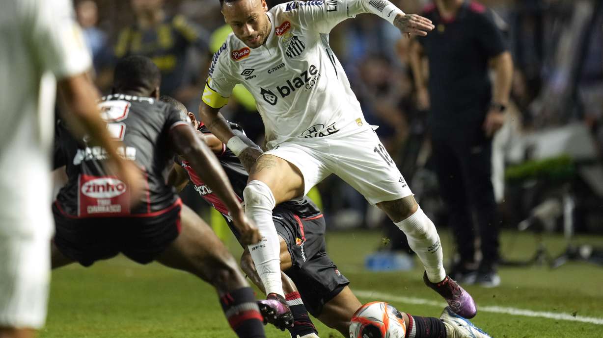 Brazil's Neymar is tackled as he chases a ball during his debut for Santos FC in a Sao Paulo league soccer match against Botafogo-SP, in Santos, Brazil, Wednesday, Feb. 5, 2025.