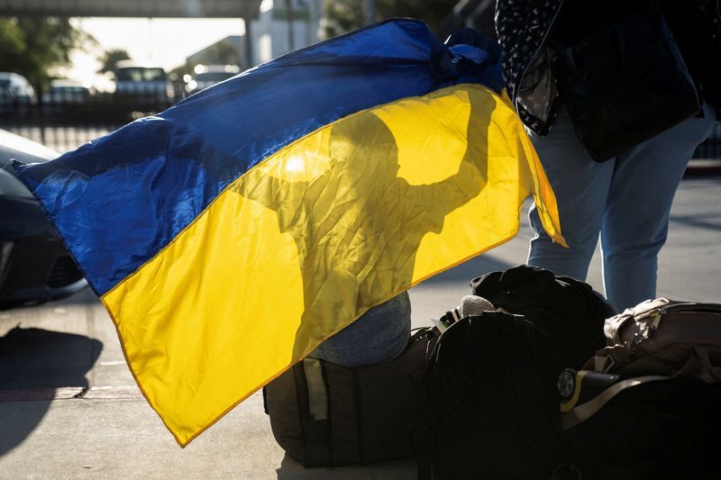 A Ukrainian boy seeking asylum in the U.S. plays with a Ukrainian flag at the San Ysidro Port of Entry in San Diego, Calif., April 13, 2022. The Trump administration is planning to revoke temporary legal status for some 240,000 Ukrainians who fled the conflict with Russia.