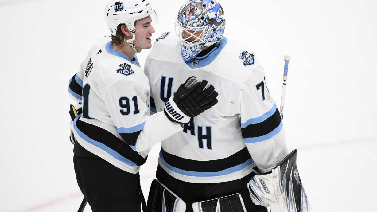 Utah Hockey Club right wing Josh Doan (91) and goaltender Karel Vejmelka, right, celebrate after an NHL hockey game against the Washington Capitals, Sunday, Feb. 9, 2025, in Washington.