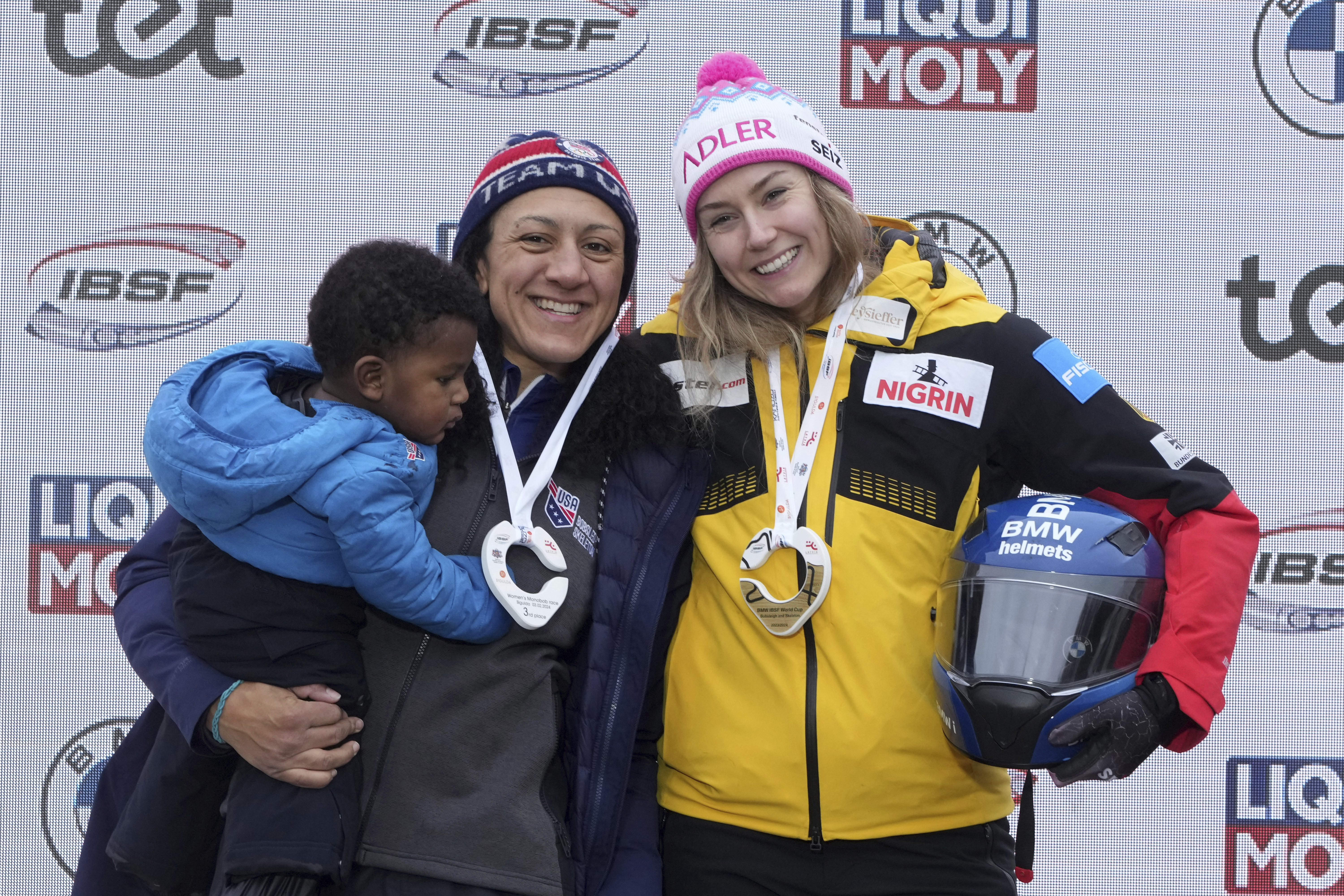 FILE - From left, third placed Elana Meyers Taylor of USA and Laura Nolte of Germany celebrate on the podium during the award ceremony of the Women's Monobob World Cup race in Sigulda, Latvia, Saturday, Feb. 3, 2024. 