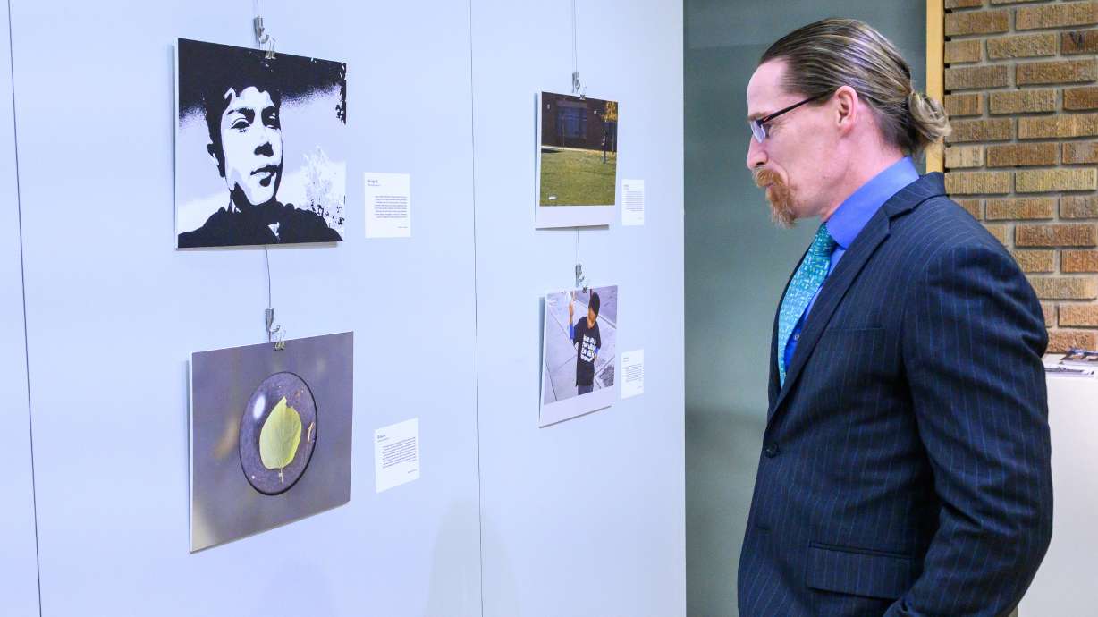Salt Lake Community College President Greg Peterson looks at the photographs on display as part of the Beloved Community Photography Project for students at the college's Eccles Gallery in Salt Lake City on Tuesday.