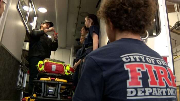 An Orem firefighter shows Alpine School District students how to perform first aid.