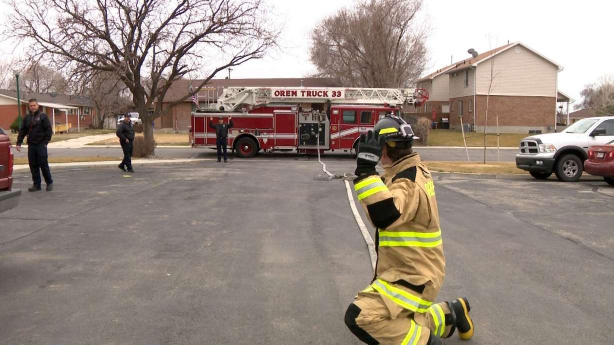 An Alpine School District student learns how to roll out the hose from an Orem fire truck.