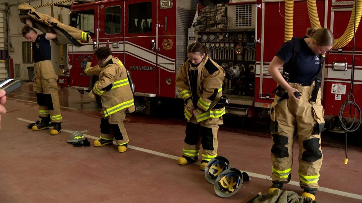 Alpine School District high school students, including Layla Bonham and Ben Anderson, gear up in firefighter gear.