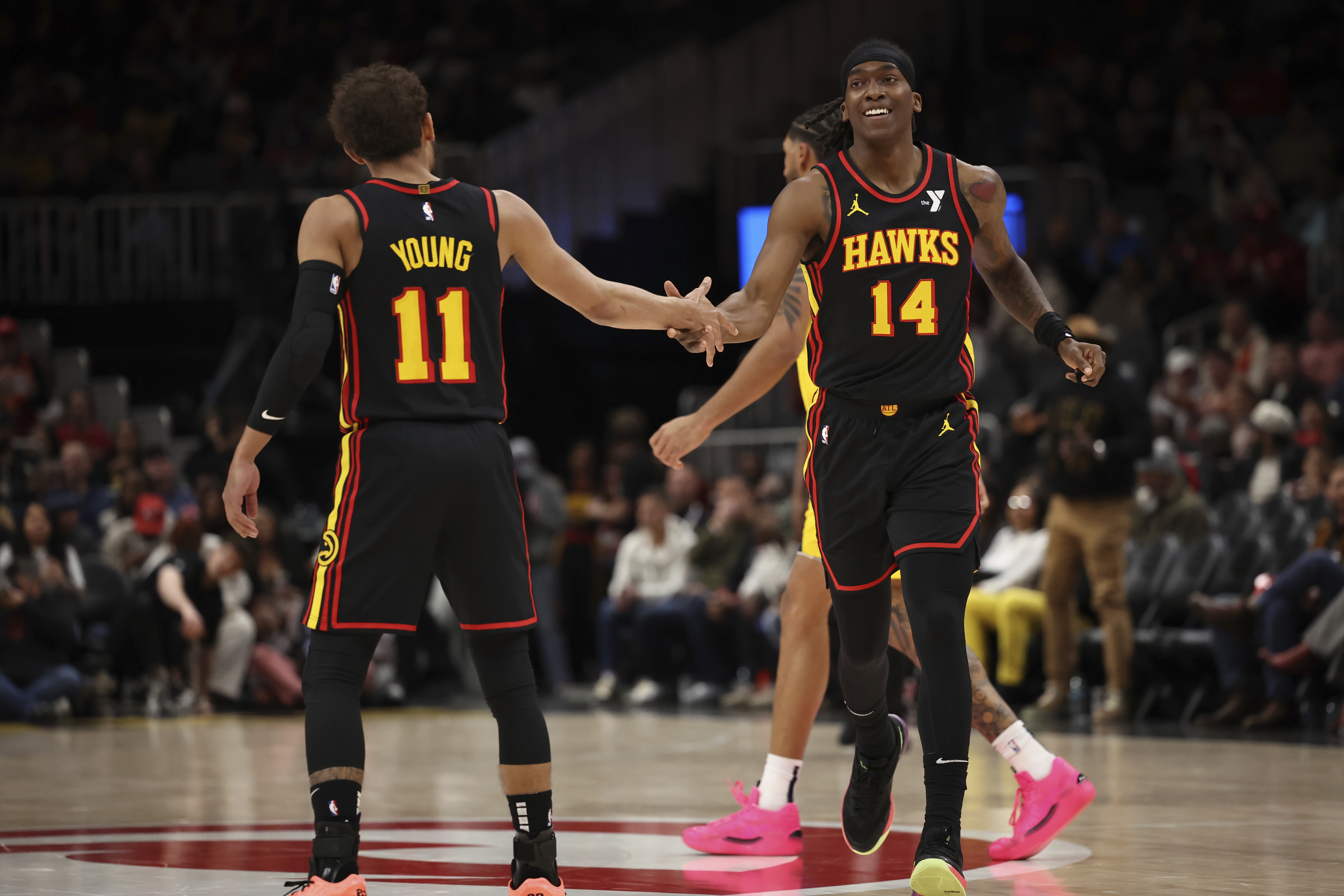 Atlanta Hawks guard Trae Young (11) celebrates with teammate terance Mann (14) in the first half of an NBA basketball game, Thursday, March 6, 2025, in Atlanta. 