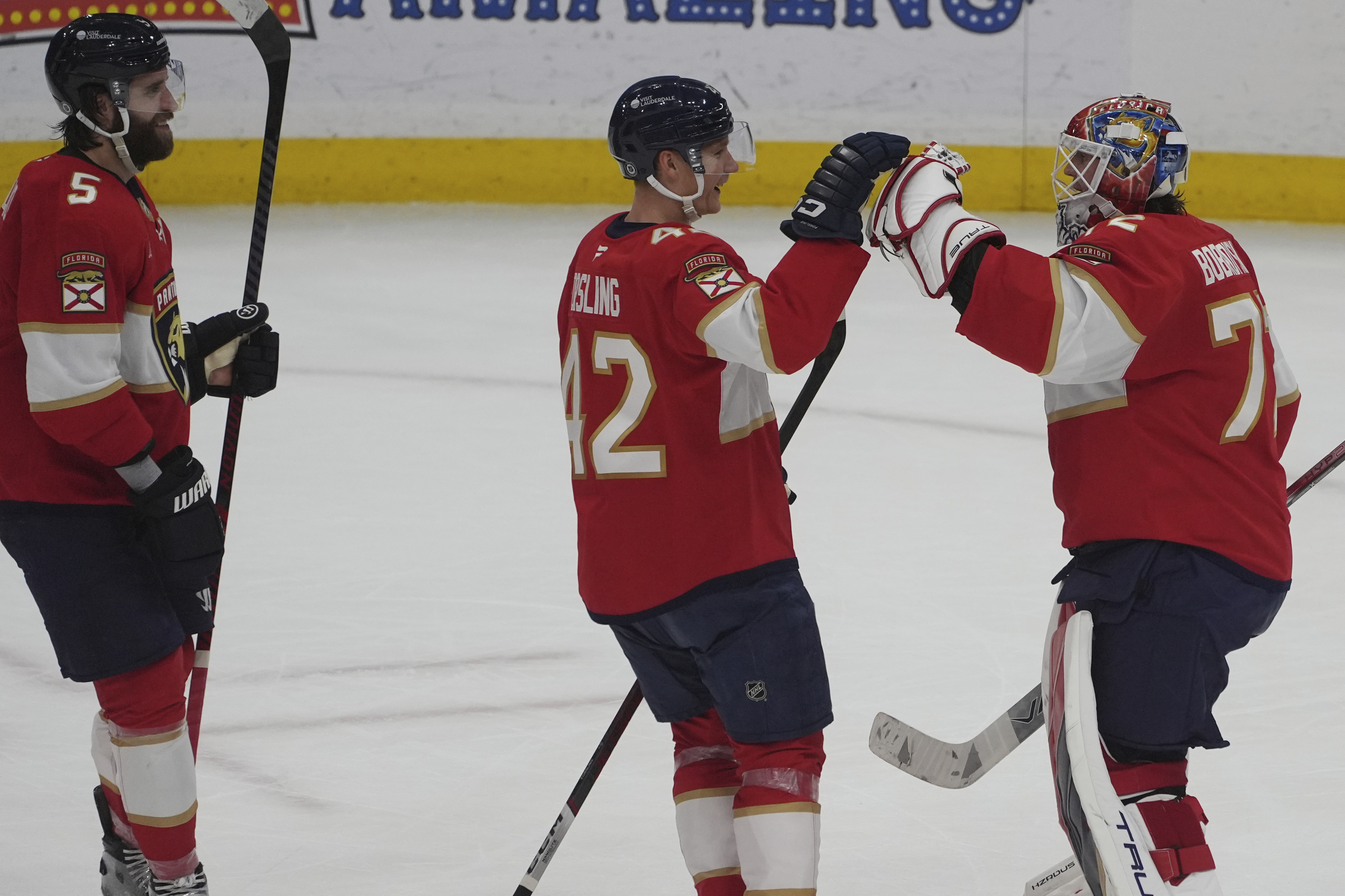 Florida Panthers defensemen Gustav Forsling (42) and Aaron Ekblad (5) celebrate with goaltender Sergei Bobrovsky (72) after defeating the Columbus Blue Jackets at an NHL hockey game, Thursday, March 6, 2025, in Sunrise, Fla.