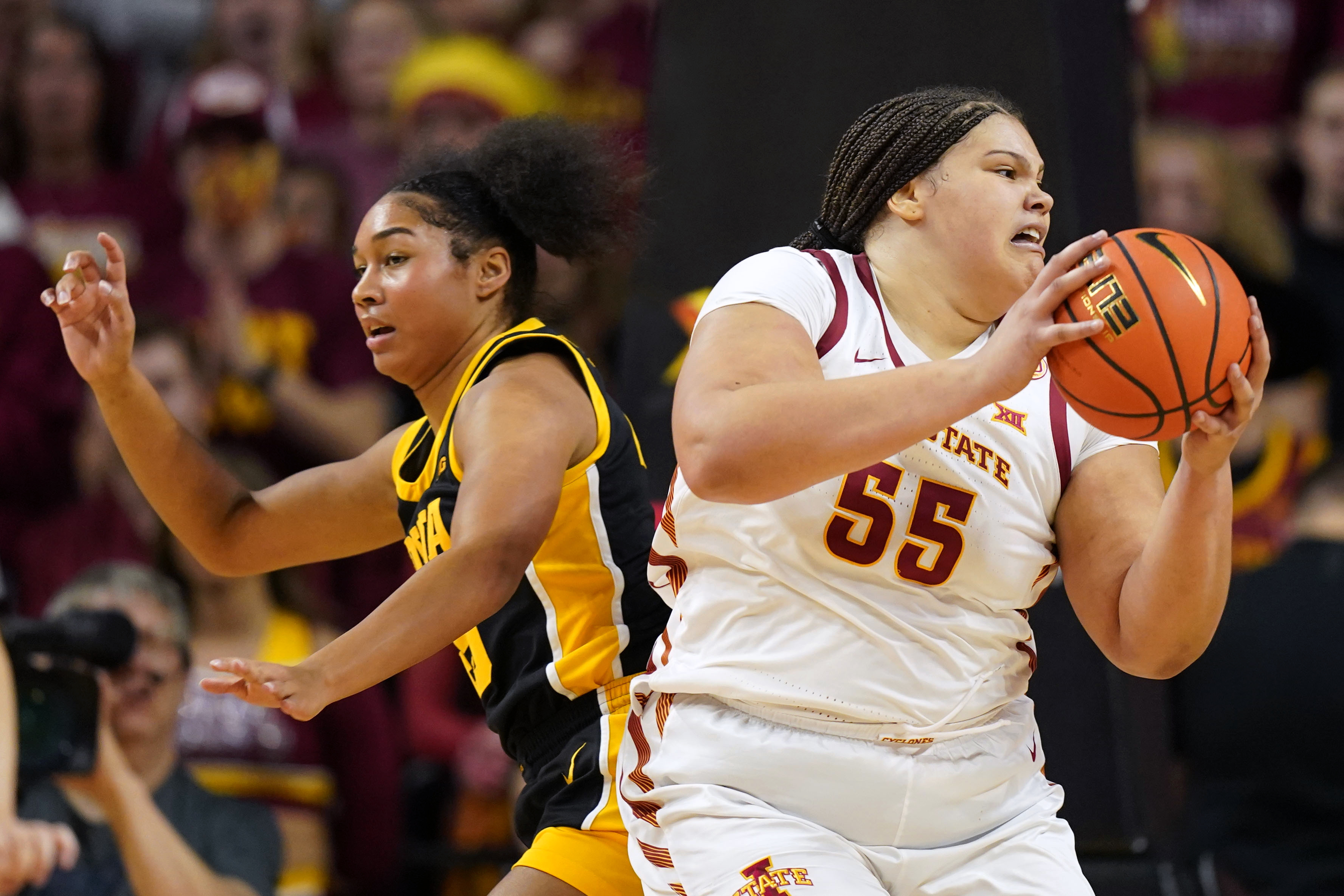 FILE - Iowa State center Audi Crooks (55) catches a pass in front of Iowa forward Hannah Stuelke, left, during the first half of an NCAA college basketball game, Wednesday, Dec. 6, 2023, in Ames, Iowa.