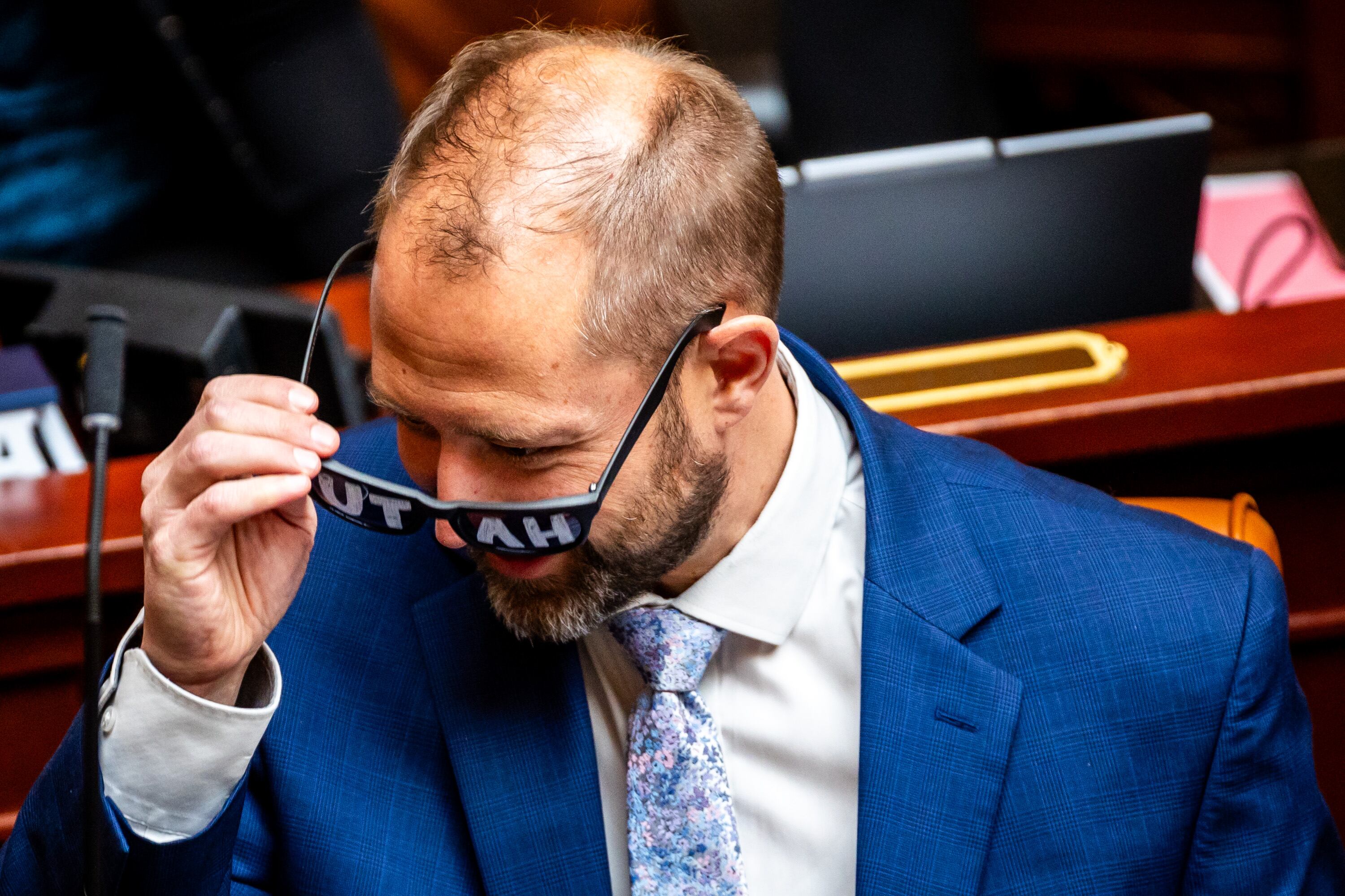 Jordan Teuscher, R-South Jordan, takes off “Utah” glasses during the Utah Legislature’s General Session at the state Capitol in Salt Lake City on Monday. Teuscher shared that a bill banning public sector collective bargaining has been a work in progress for years.