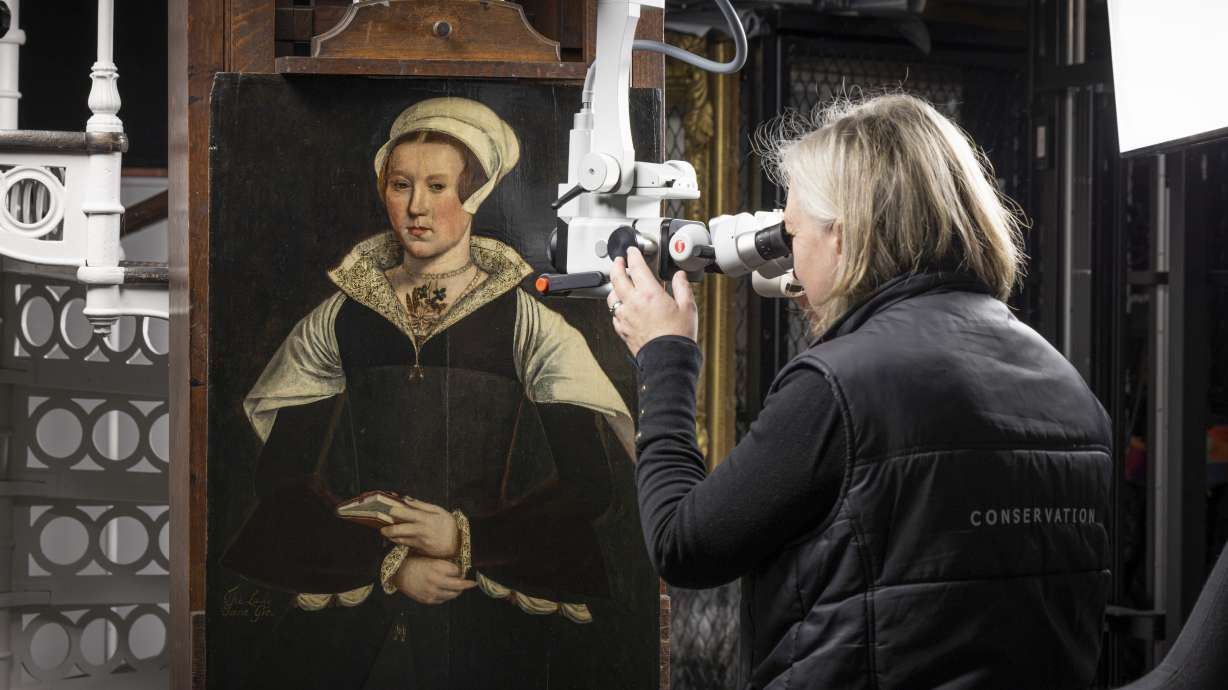 In this photo provided by English Heritage, English Heritage Conservator Rachel Turnbull gives a portrait believed to be of Lady Jane Grey a final examination before it goes on display at Wrest Park in Bedfordshire, England, Feb. 27.