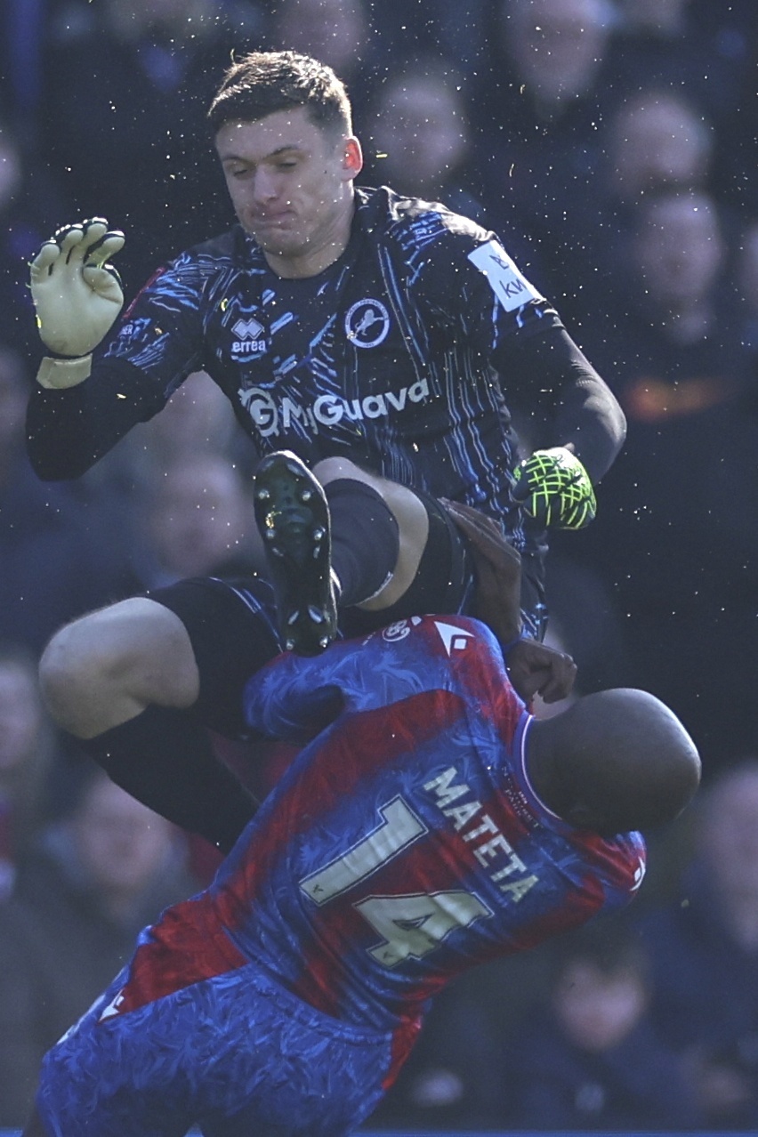 Crystal Palace's Jean-Philippe Mateta is fouled by Millwall goalkeeper Liam Roberts, for which he got a red card, during the English FA Cup soccer match between Crystal Palace and Millwall at Selhurst Park, London, England, Saturday, March 1, 2025. 