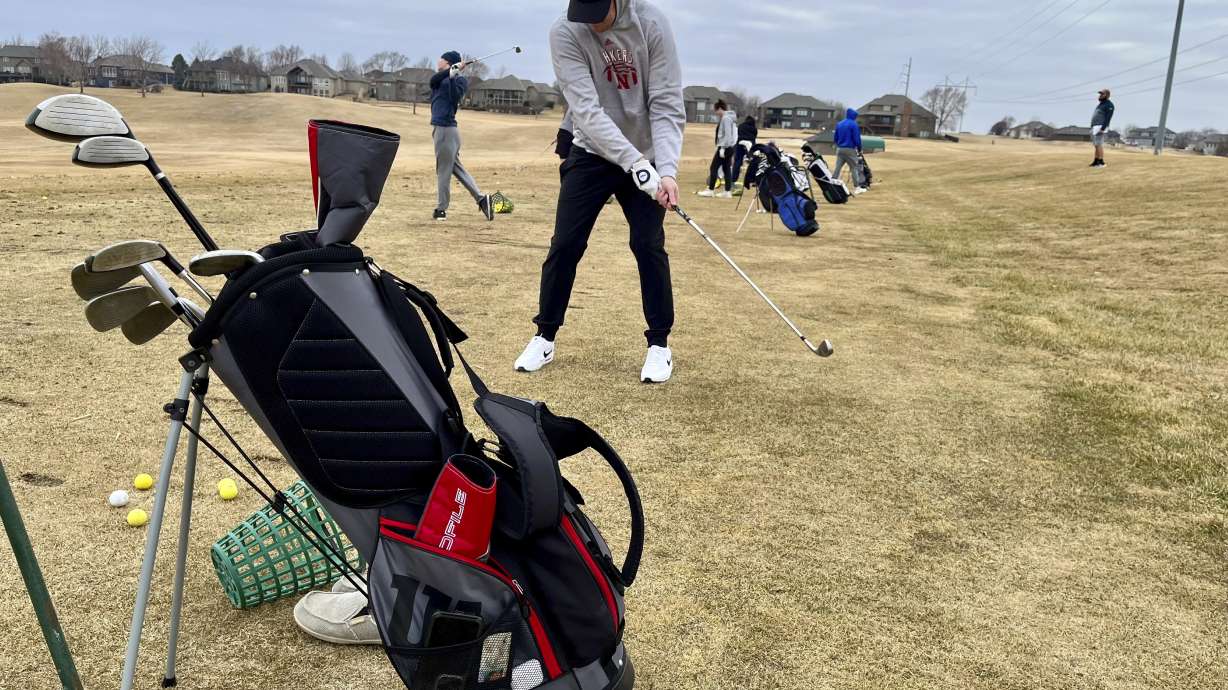Golfers line up to take some practice shots on the driving range of the Stone Creek Golf Course in Omaha, Neb. on Monday afternoon, March 3, 2025, before hitting the links.
