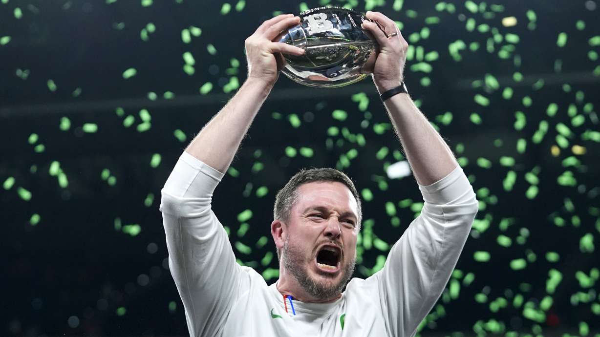 FILE- Oregon head coach Dan Lanning celebrates with the trophy after defeating against Penn State in the Big Ten Conference championship NCAA college football game, Saturday, Dec. 7, 2024, in Indianapolis.