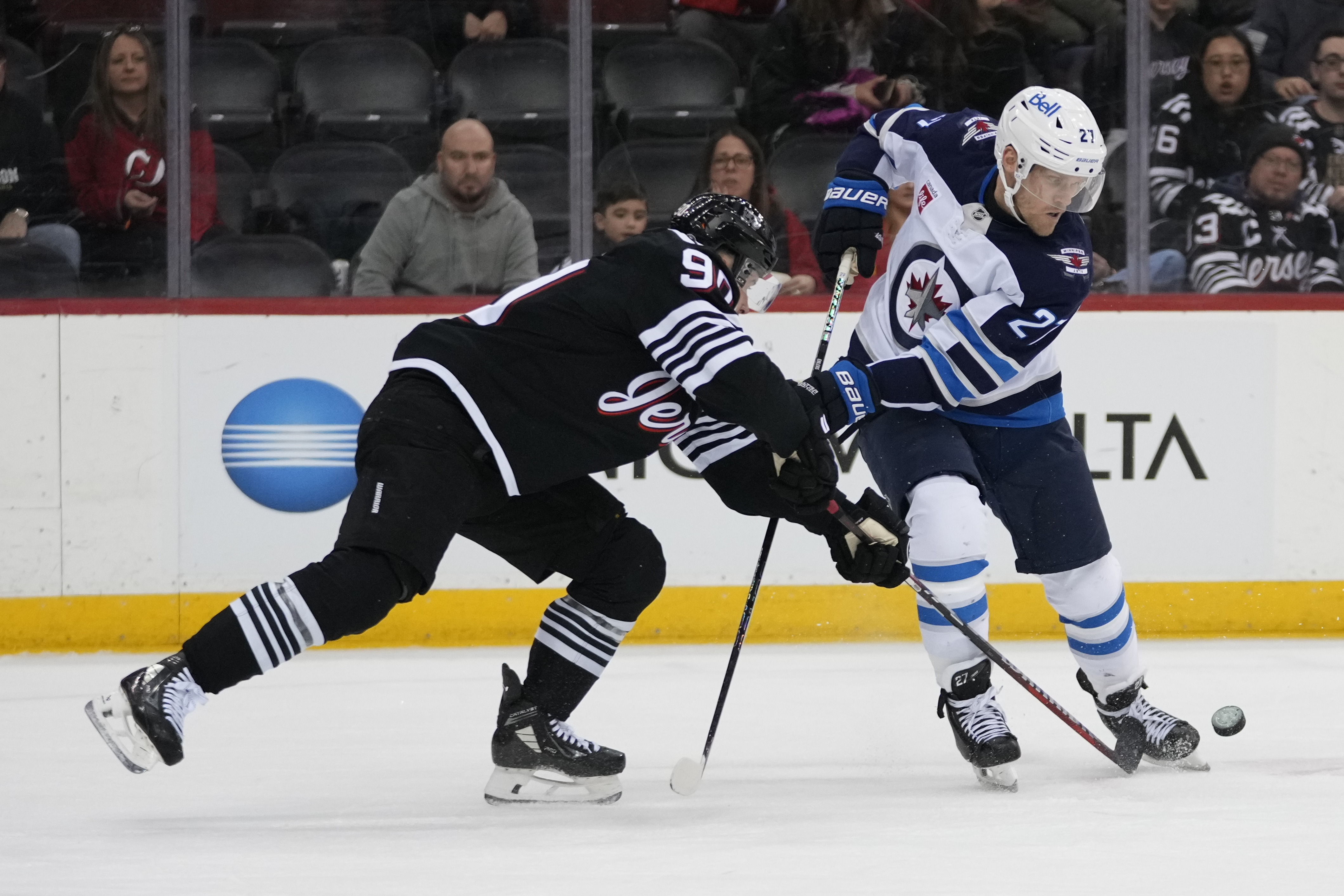 New Jersey Devils' Tomas Tatar, left, fights for control of the puck with Winnipeg Jets' Nikolaj Ehlers (27) during the first period of an NHL hockey game Friday, March 7, 2025, in Newark, N.J. 