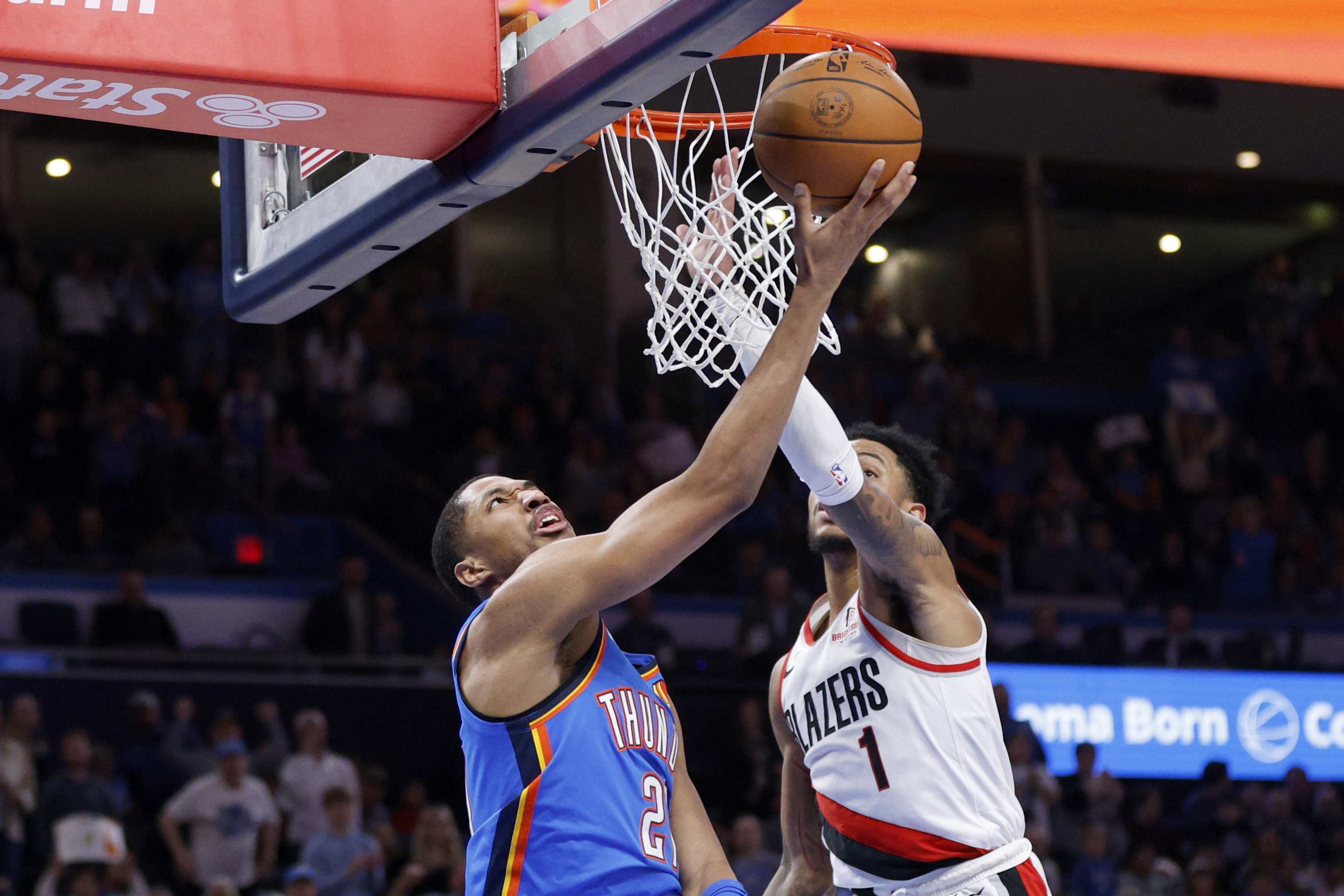 Oklahoma City Thunder guard Aaron Wiggins, left, looks to shoot against Portland Trail Blazers guard Anfernee Simons (1) during the first half of an NBA basketball game Friday, March 7, 2025, in Oklahoma City.