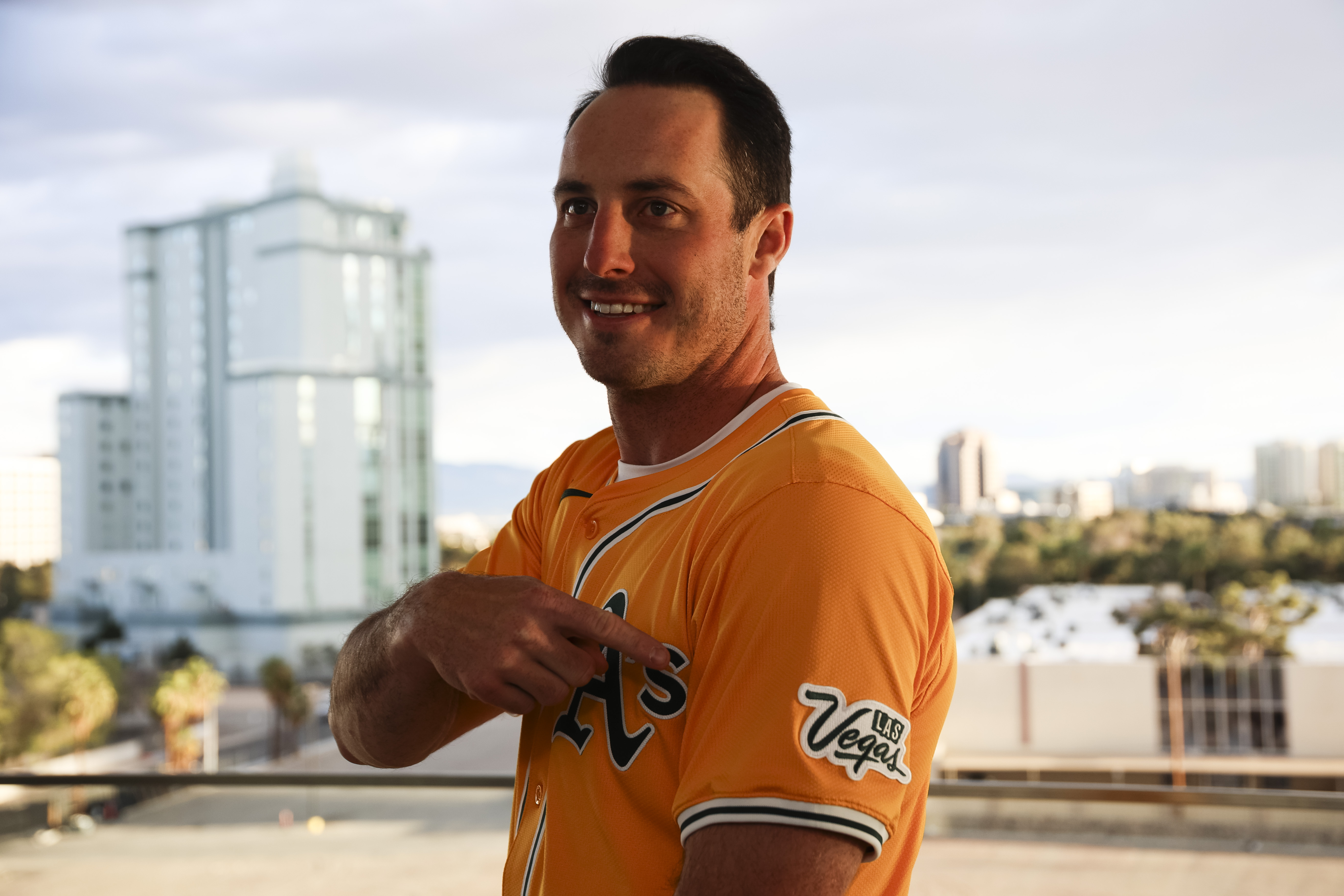 Athletics player Brent Rooker points to a Las Vegas logo on his jersey during a press conference, Friday, March 7, 2025, in Las Vegas. 