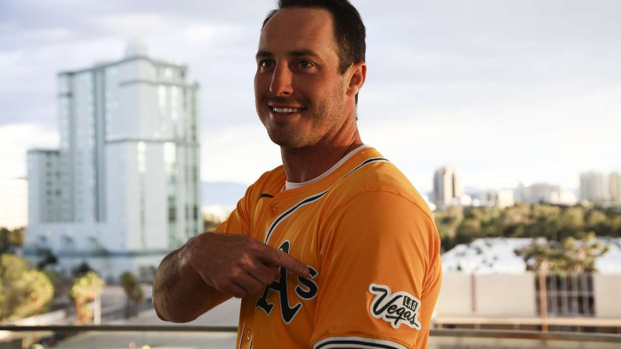Athletics player Brent Rooker points to a Las Vegas logo on his jersey during a press conference, Friday, March 7, 2025, in Las Vegas.