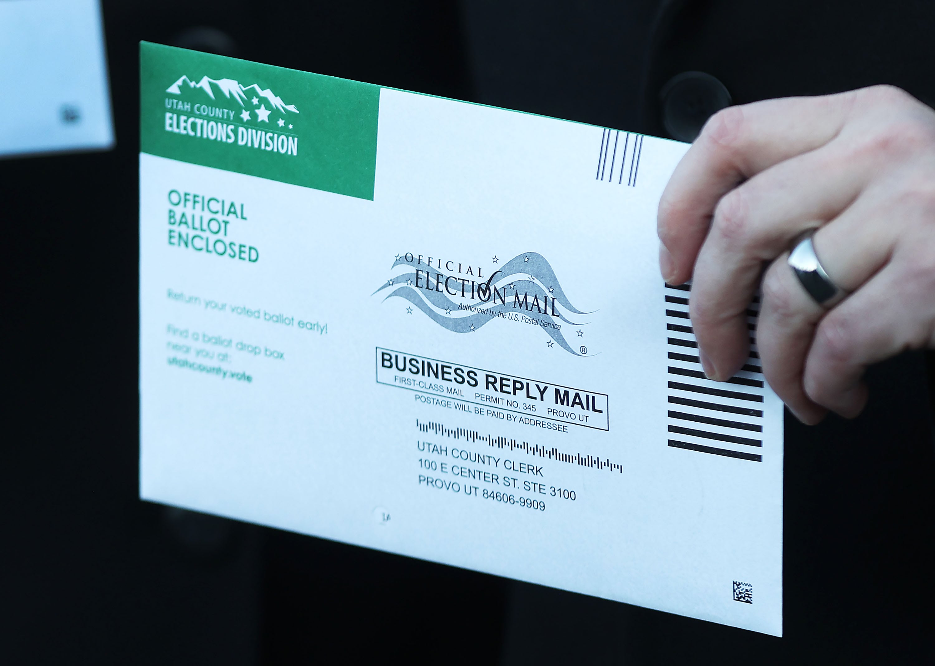 A voter holds a mail-in ballot in Provo on Nov. 4, 2022.