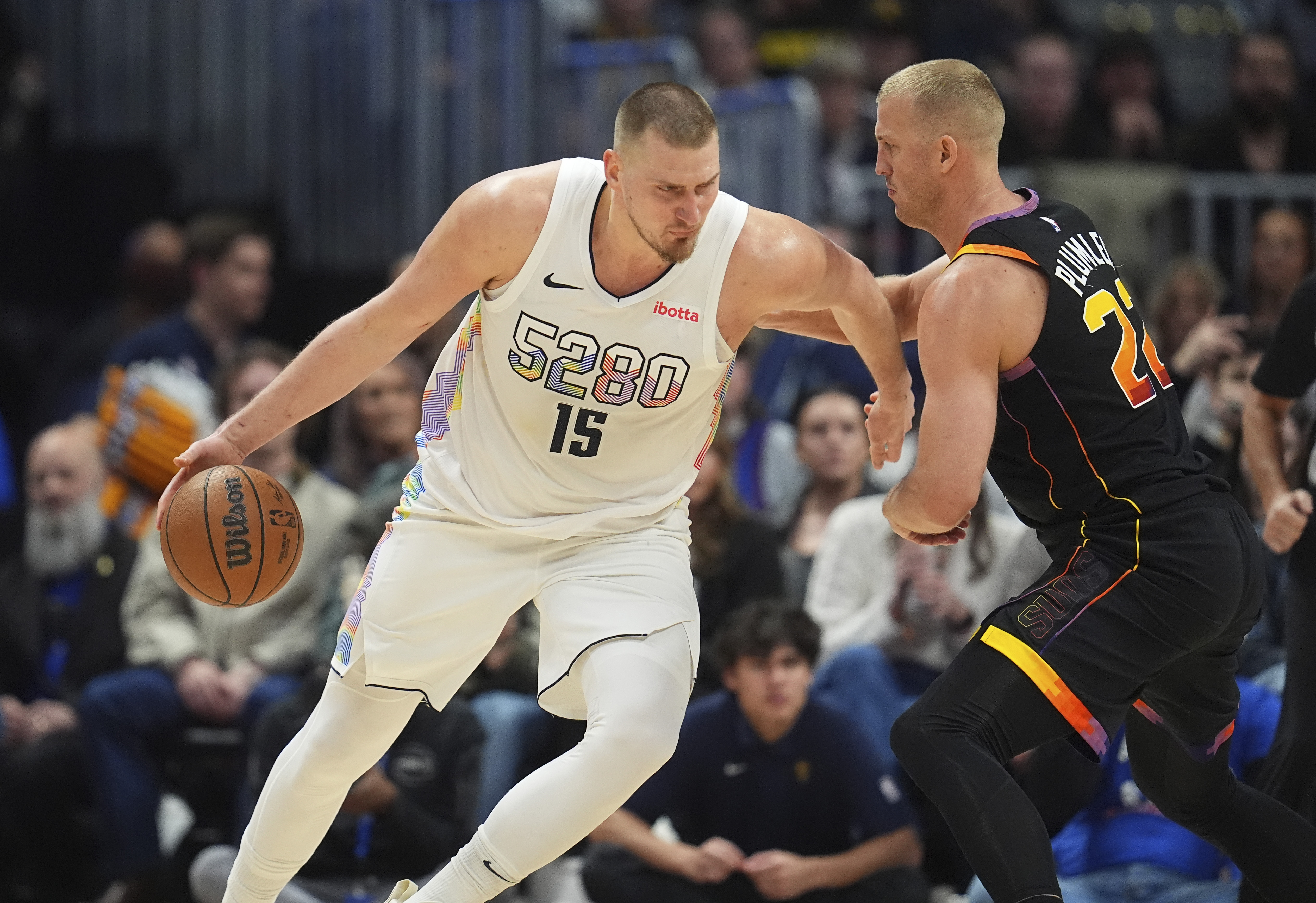 Denver Nuggets center Nikola Jokic, left, drives to the basket as Phoenix Suns center Mason Plumlee defends in the second half of an NBA basketball game Friday, March 7, 2025, in Denver. 