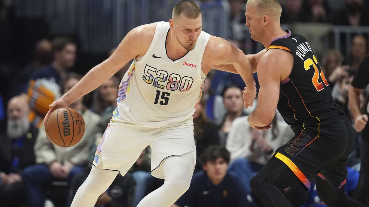 Denver Nuggets center Nikola Jokic, left, drives to the basket as Phoenix Suns center Mason Plumlee defends in the second half of an NBA basketball game Friday, March 7, 2025, in Denver.