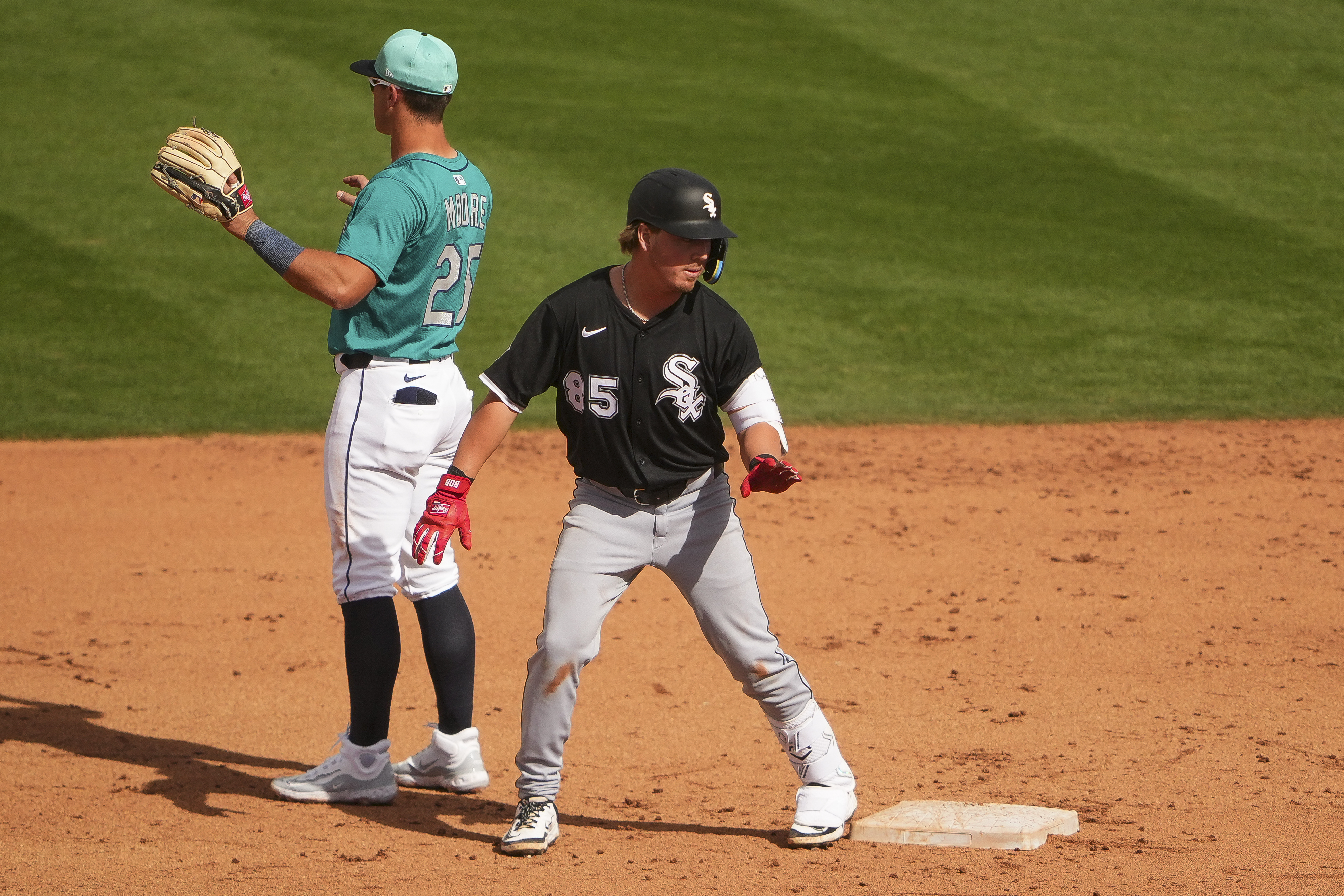 Chicago White Sox's Chase Meidroth looks on after hitting an RBI double as Seattle Mariners second baseman Dylan Moore motions to the outfield during the fifth inning of a spring training baseball game Saturday, March 1, 2025, in Peoria, Ariz.