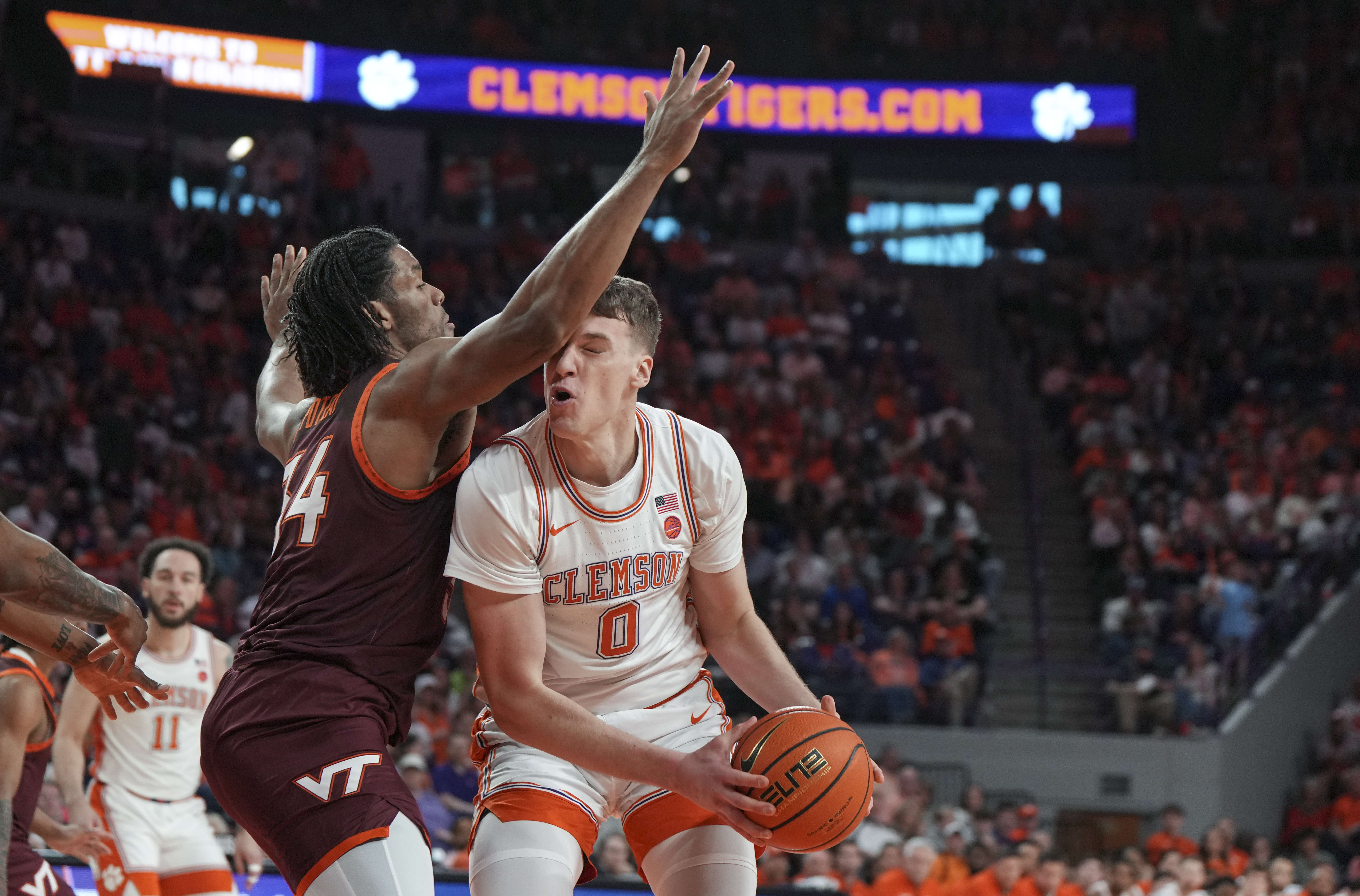 Clemson center Viktor Lakhin (0) is defended by Virginia Tech forward Mylyjael Poteat, front left, during the first half of an NCAA college basketball game Saturday, March 8, 2025, in Clemson, S.C. 