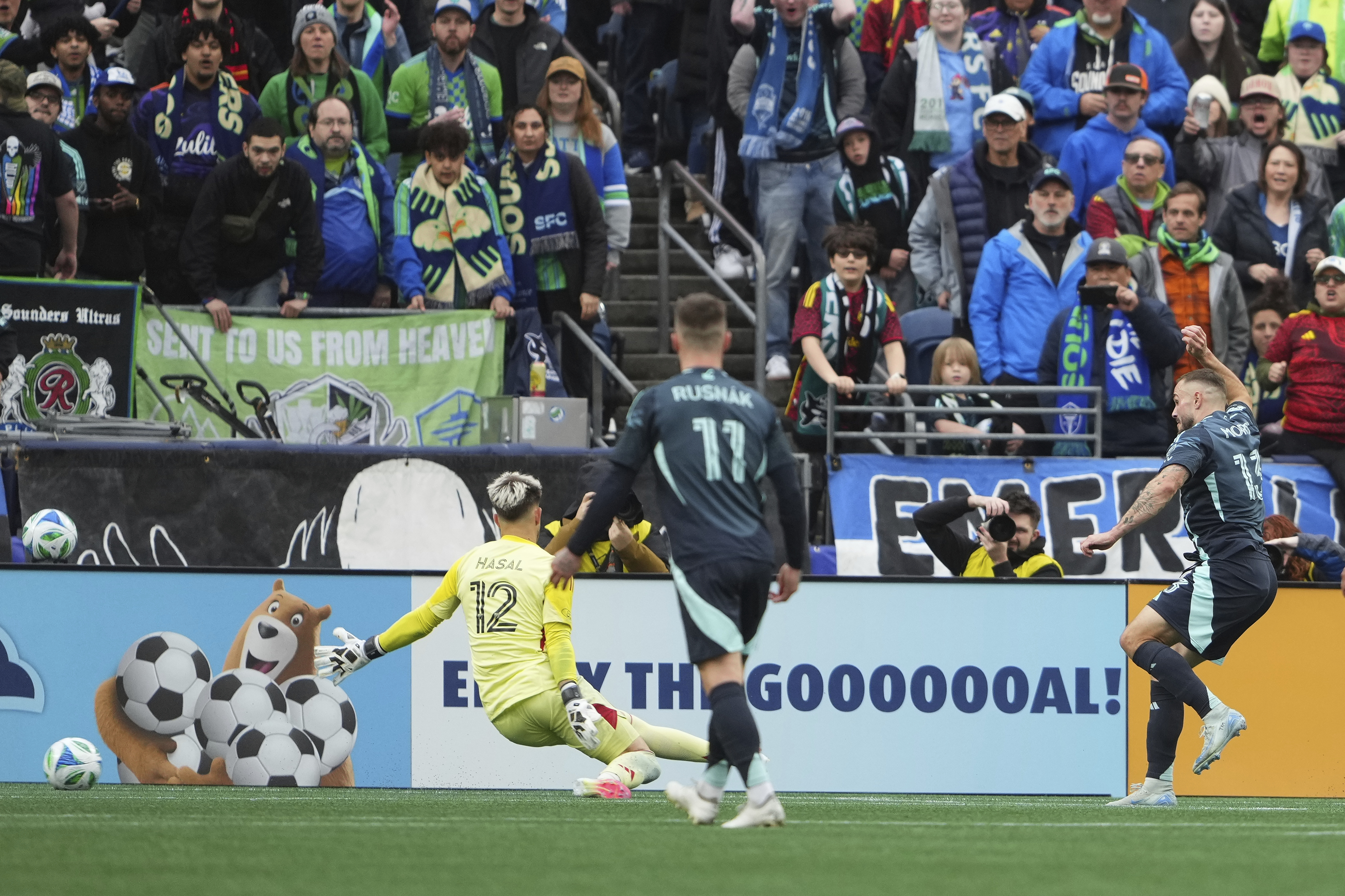 Seattle Sounders forward Jordan Morris, right, shoots and scores in front of Los Angeles FC goalkeeper Thomas Hasal (12) during the second half of an MLS soccer match Saturday, March 8, 2025, in Seattle. 