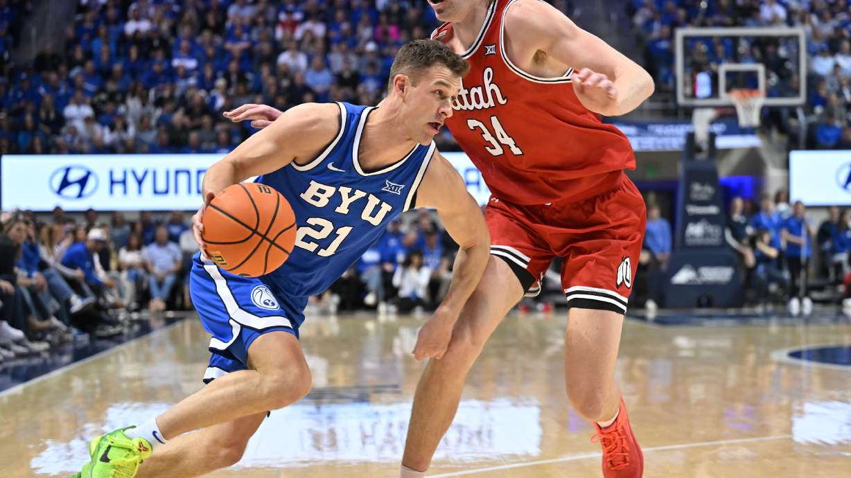 Brigham Young Cougars guard Trevin Knell (21) drives on Utah Utes center Lawson Lovering (34) as BYU and Utah play at the Marriott Center in Provo on Saturday, March 8, 2025.