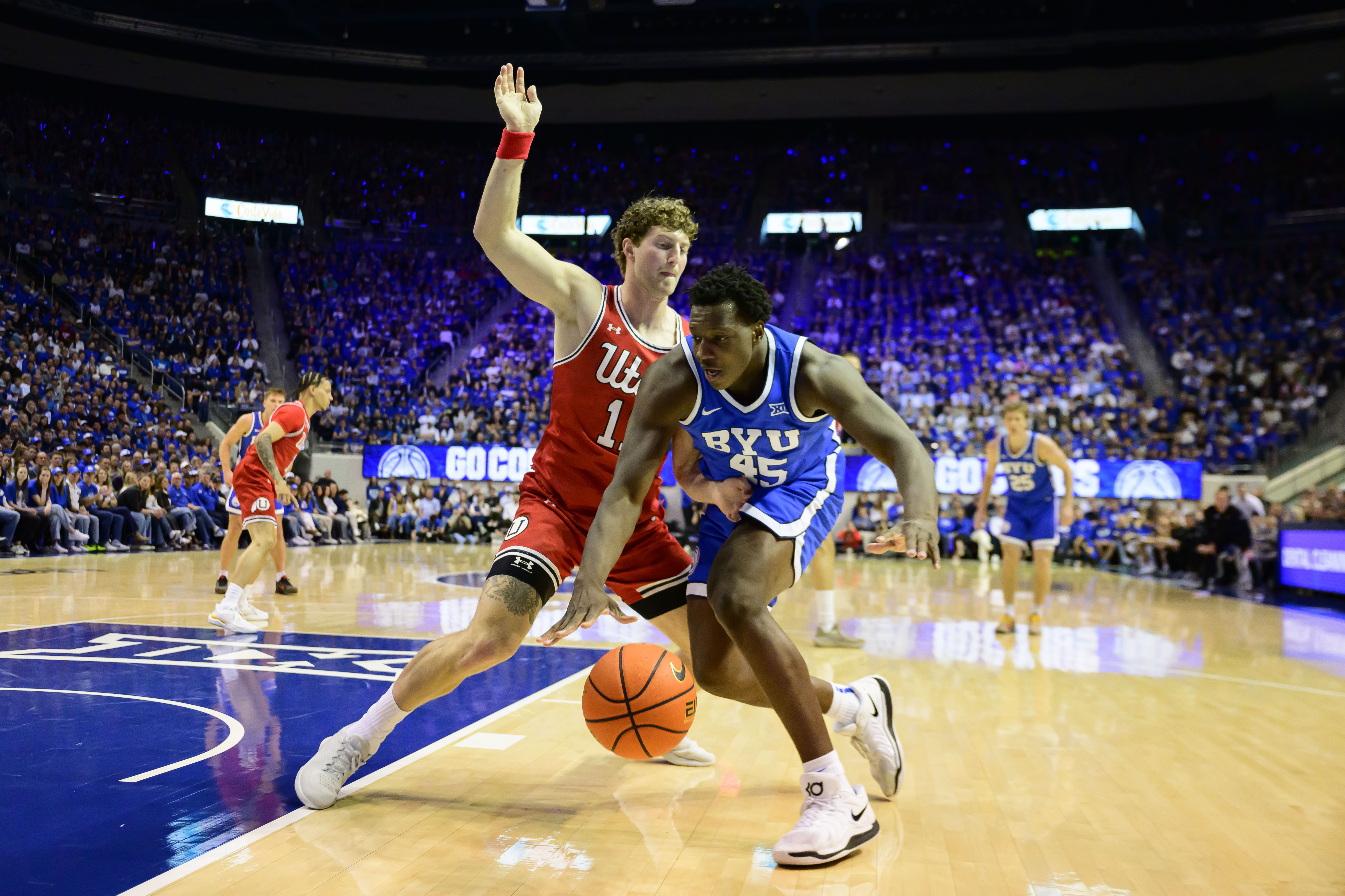 BYU center Fousseyni Traore (45) drives to the basket guarded by Utah forward Caleb Lohner (11) during the first half of an NCAA basketball game Saturday, March 8, 2025, in Provo, Utah. 