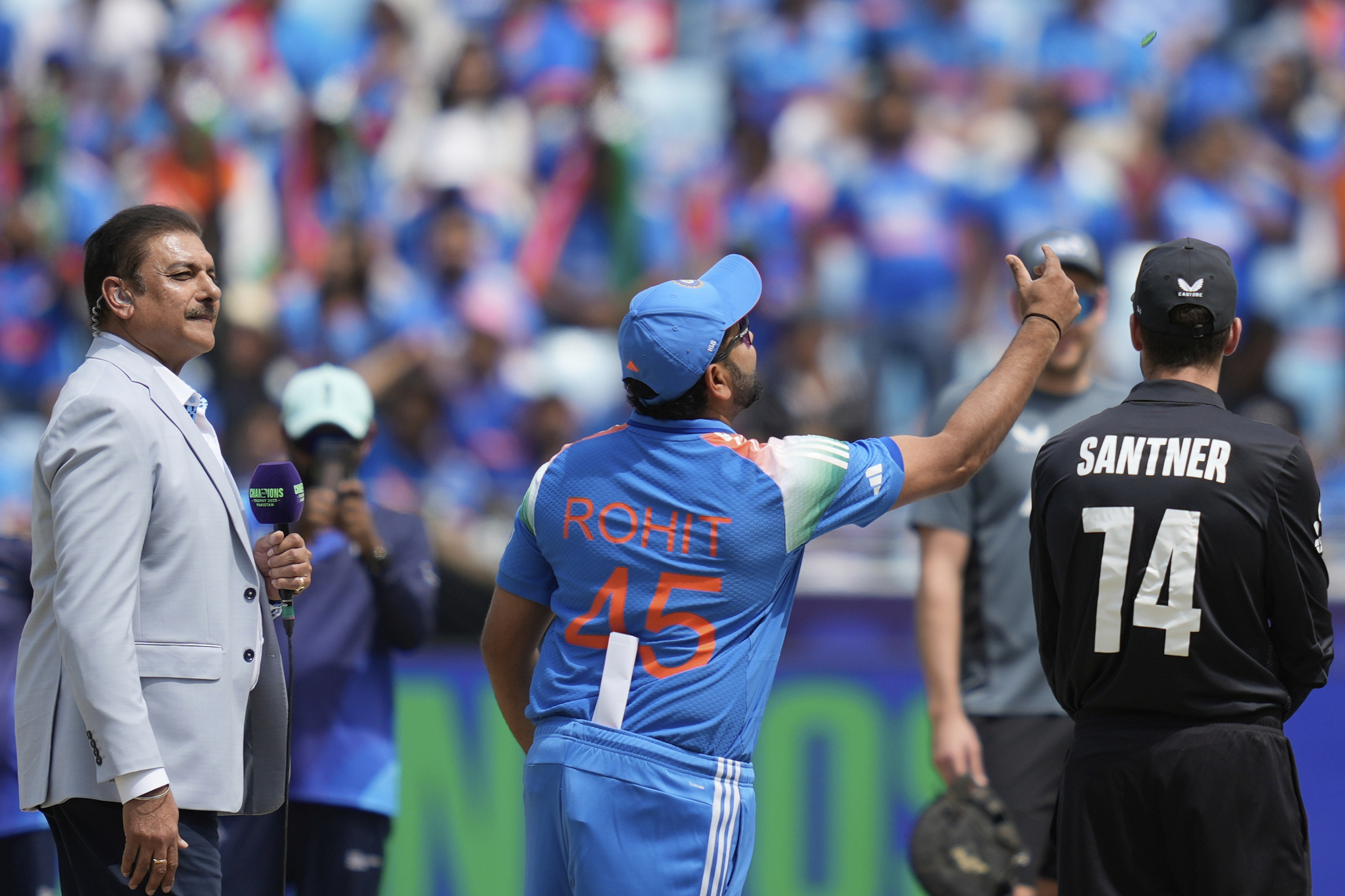 India's captain Rohit Sharma, center, flips the coin at the toss prior to the start of the ICC Champions Trophy final cricket match between India and New Zealand at Dubai International Cricket Stadium in Dubai, United Arab Emirates, Sunday, March 9, 2025. 