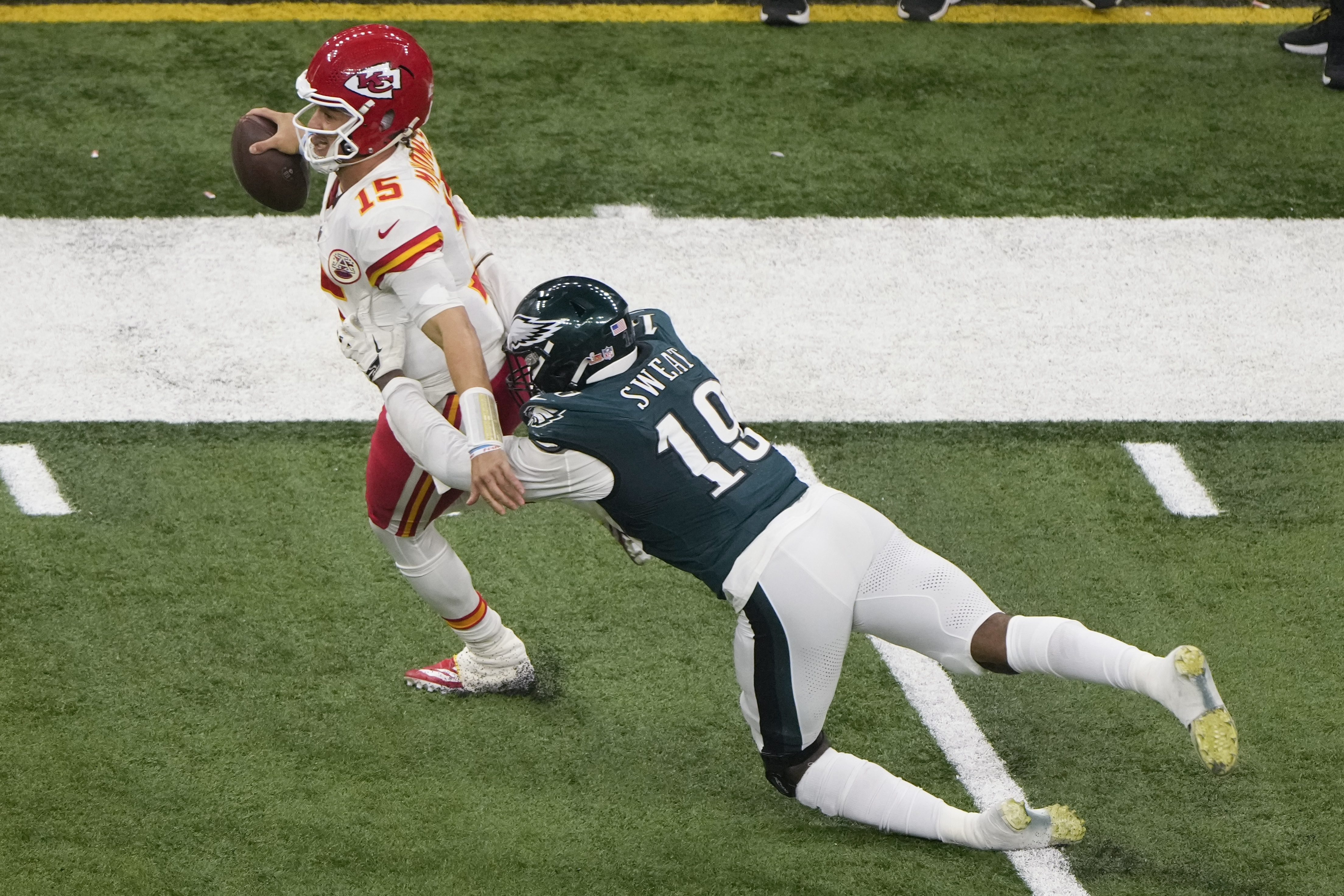 Kansas City Chiefs quarterback Patrick Mahomes (15) runs past Philadelphia Eagles linebacker Josh Sweat (19) during the second half of the NFL Super Bowl 59 football game, Sunday, Feb. 9, 2025, in New Orleans. 