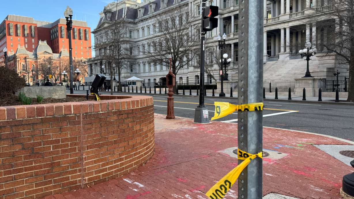 Police tape remains at the scene of an overnight shooting on a street bordering the White House complex, after Secret Service say they shot a man brandishing a firearm in Washington, Sunday.