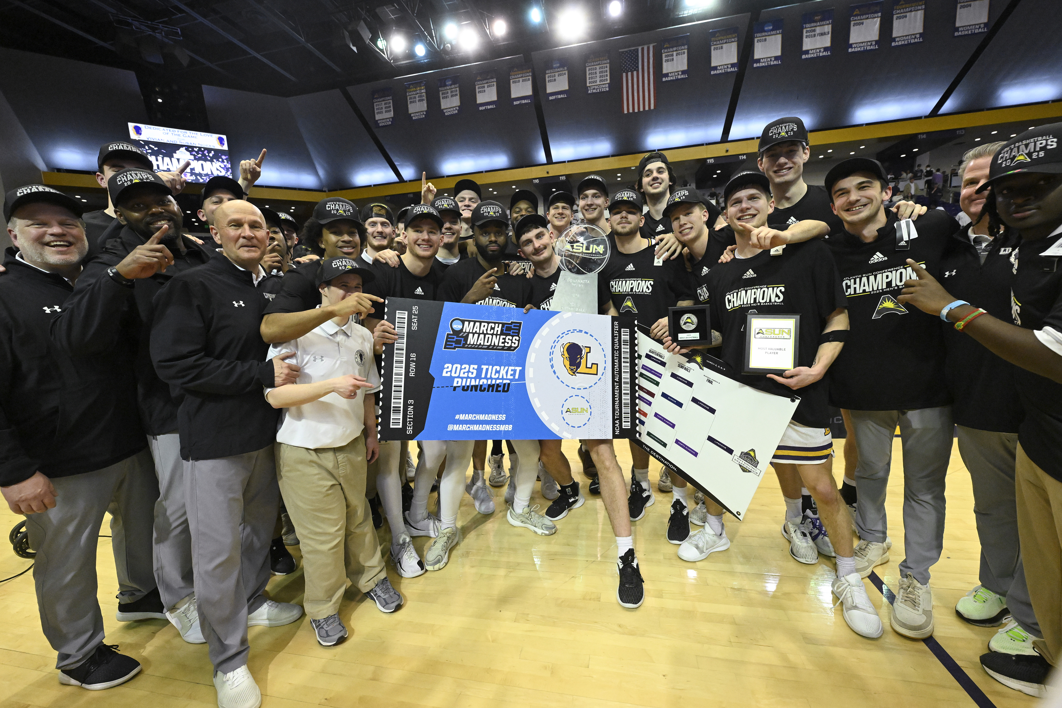 Lipscomb team members pose with a tournament bracket after winning the Atlantic Sun Conference championship NCAA college basketball game against North Alabama, Sunday, March 9, 2025, in Nashville, Tenn. 