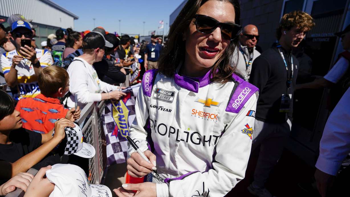 Katherine Legge signs autographs before the start of a NASCAR Cup Series at Phoenix Raceway, Sunday, March 9, 2025, in Avondale, Ariz.