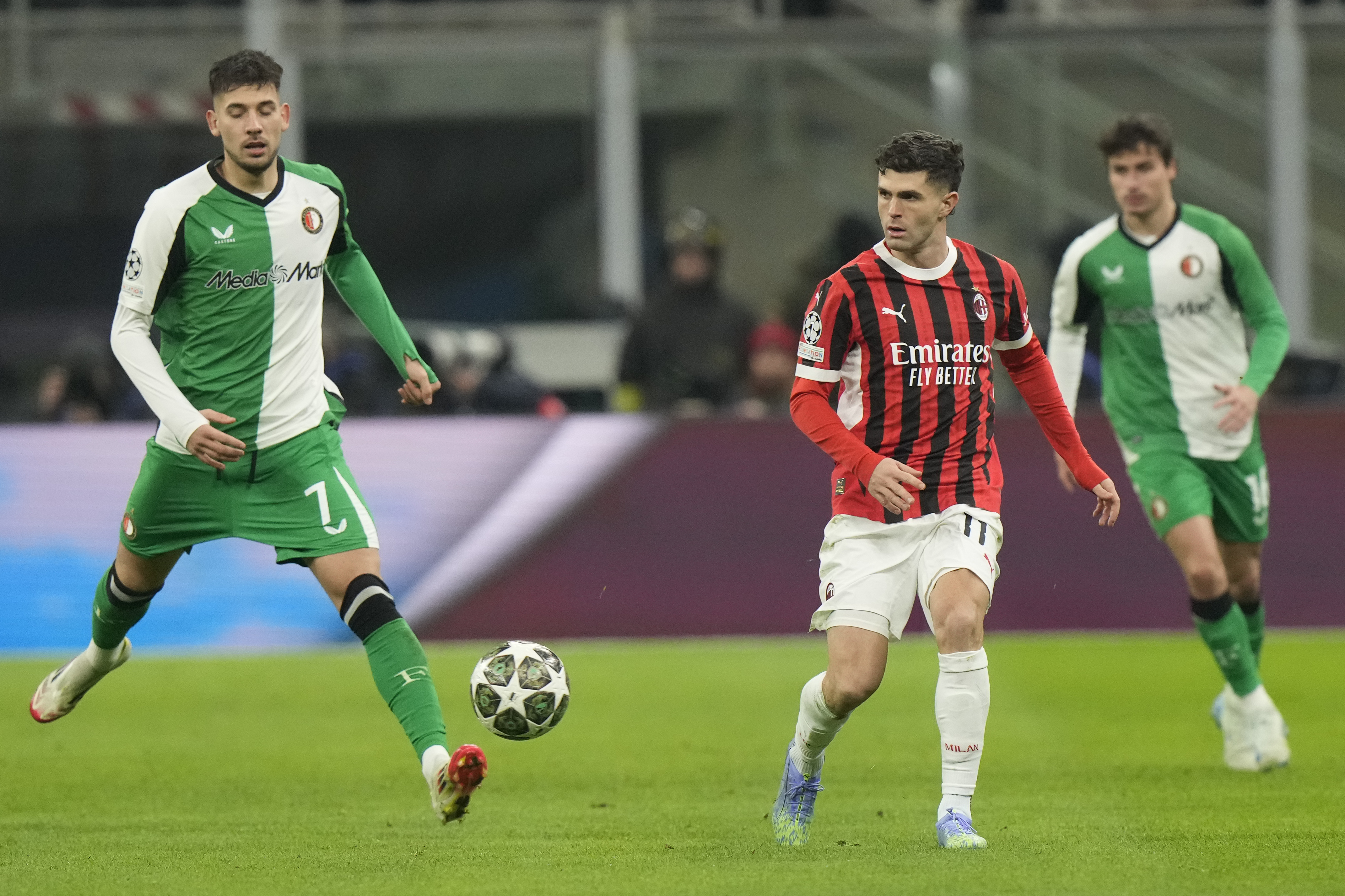 AC Milan's Christian Pulisic, right, challenges for the ball with Feyenoord's Jakub Moder during Champions League, playoff second leg soccer match between AC Milan and Feyenoord, at the San Siro stadium in Milan, Italy, Tuesday, Feb.18, 2025. 