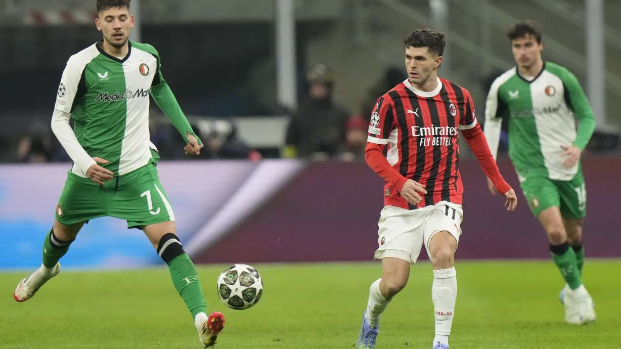 AC Milan's Christian Pulisic, right, challenges for the ball with Feyenoord's Jakub Moder during Champions League, playoff second leg soccer match between AC Milan and Feyenoord, at the San Siro stadium in Milan, Italy, Tuesday, Feb.18, 2025.