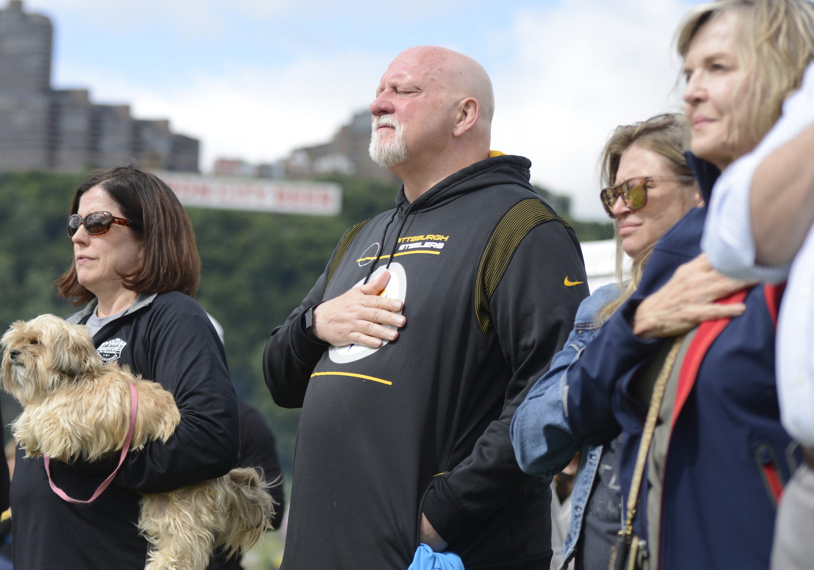 FILE - Craig Wolfley, center, a former Pittsburgh Steelers NFL football player, becomes emotional during the national anthem at the 20th Annual Tunch and Wolf Walk for the Homeless on Saturday, June 18, 2022, on Pittsburgh's North Shore. 