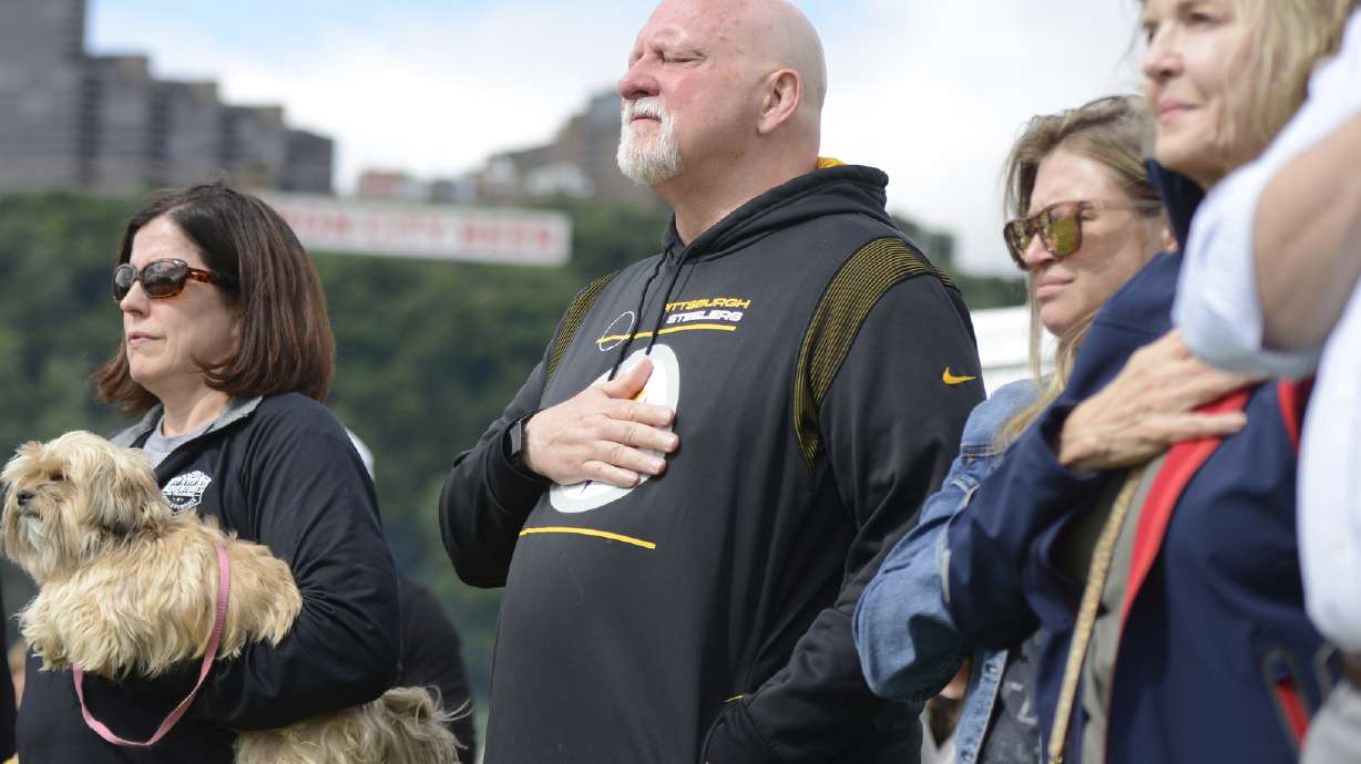 FILE - Craig Wolfley, center, a former Pittsburgh Steelers NFL football player, becomes emotional during the national anthem at the 20th Annual Tunch and Wolf Walk for the Homeless on Saturday, June 18, 2022, on Pittsburgh's North Shore.
