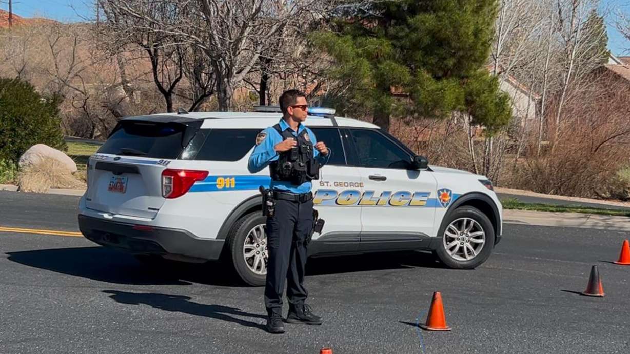 A St. George Police officer directs traffic away from a road leading to a fatal crash scene in St. George on Sunday.