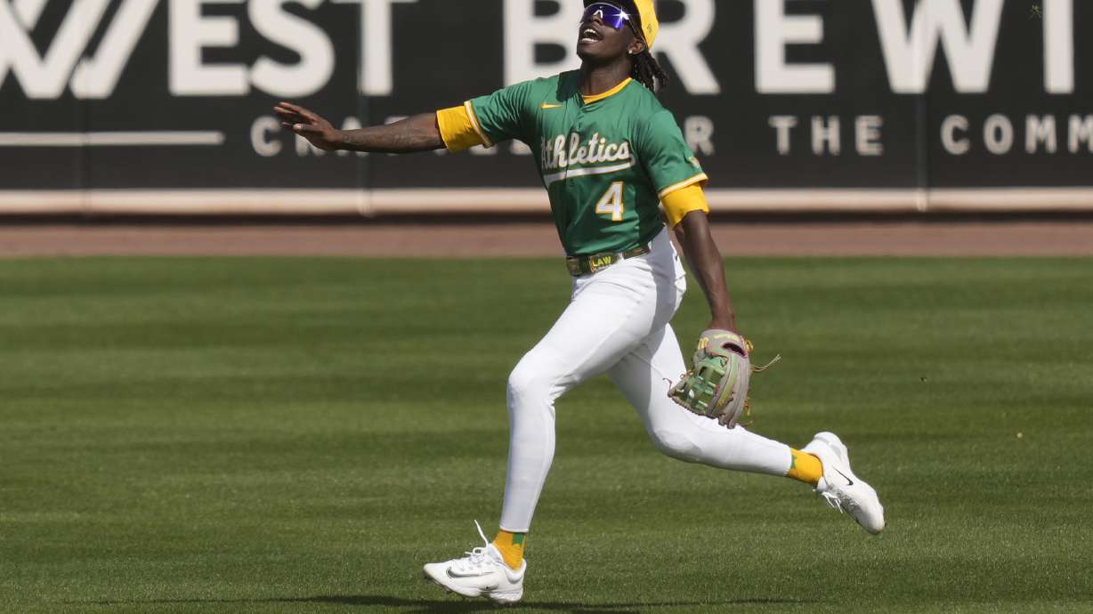 Athletics right fielder Lawrence Butler shouts runs to catch a fly ball hit by Cincinnati Reds' Jeimer Candelario during the second inning of a spring training baseball game, Friday, Feb. 28, 2025, in Mesa, Ariz.