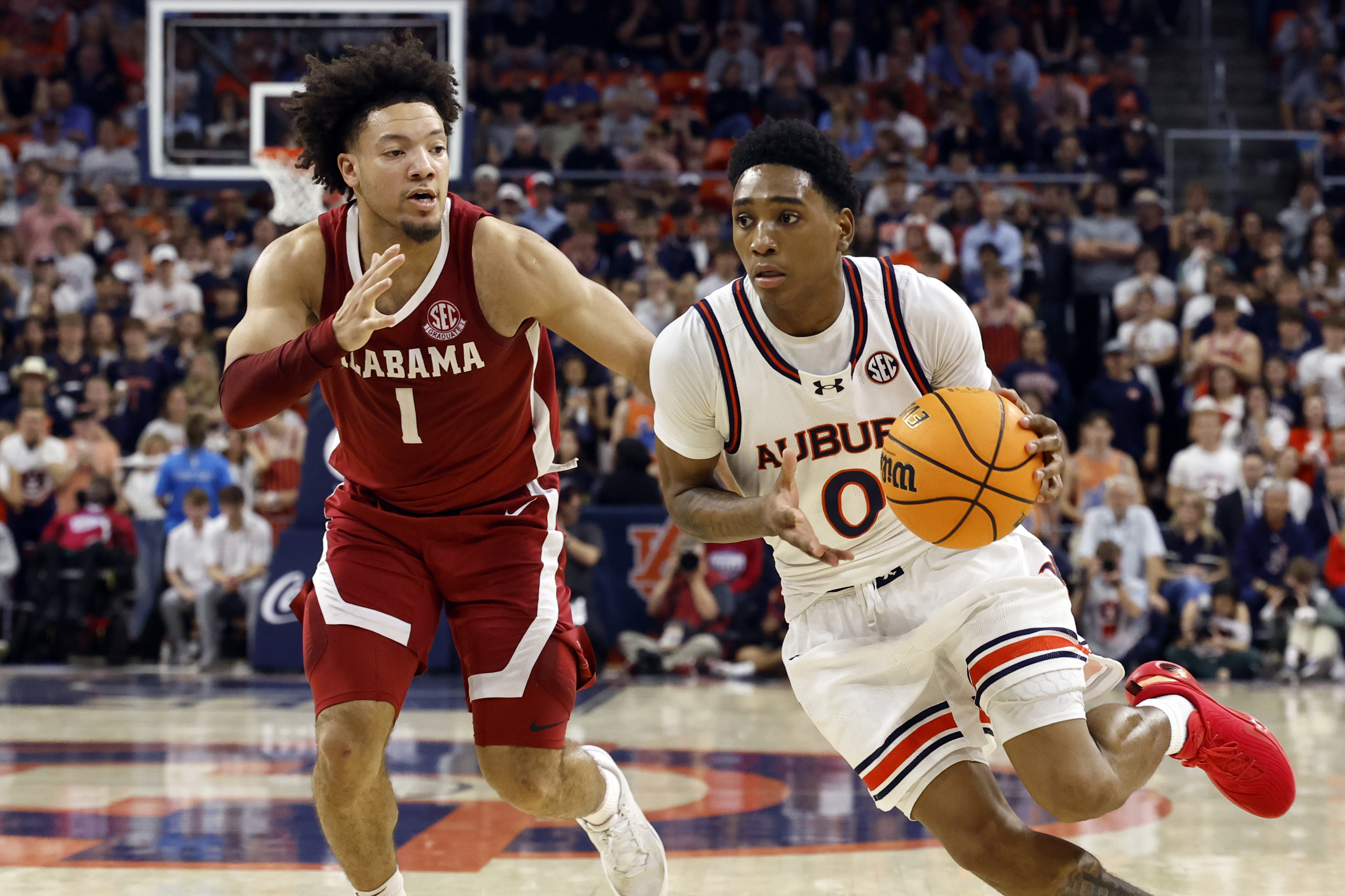 Auburn guard Tahaad Pettiford (0) drives to the basket around Alabama guard Mark Sears (1) during the second half of an NCAA college basketball game, Saturday, March 8, 2025, in Auburn, Ala. 
