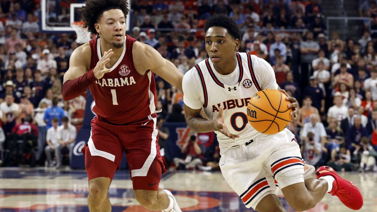 Auburn guard Tahaad Pettiford (0) drives to the basket around Alabama guard Mark Sears (1) during the second half of an NCAA college basketball game, Saturday, March 8, 2025, in Auburn, Ala.