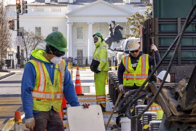 With the White House in the background, a worker watches as demolition begins on the Black Lives Matter mural, Monday in Washington.