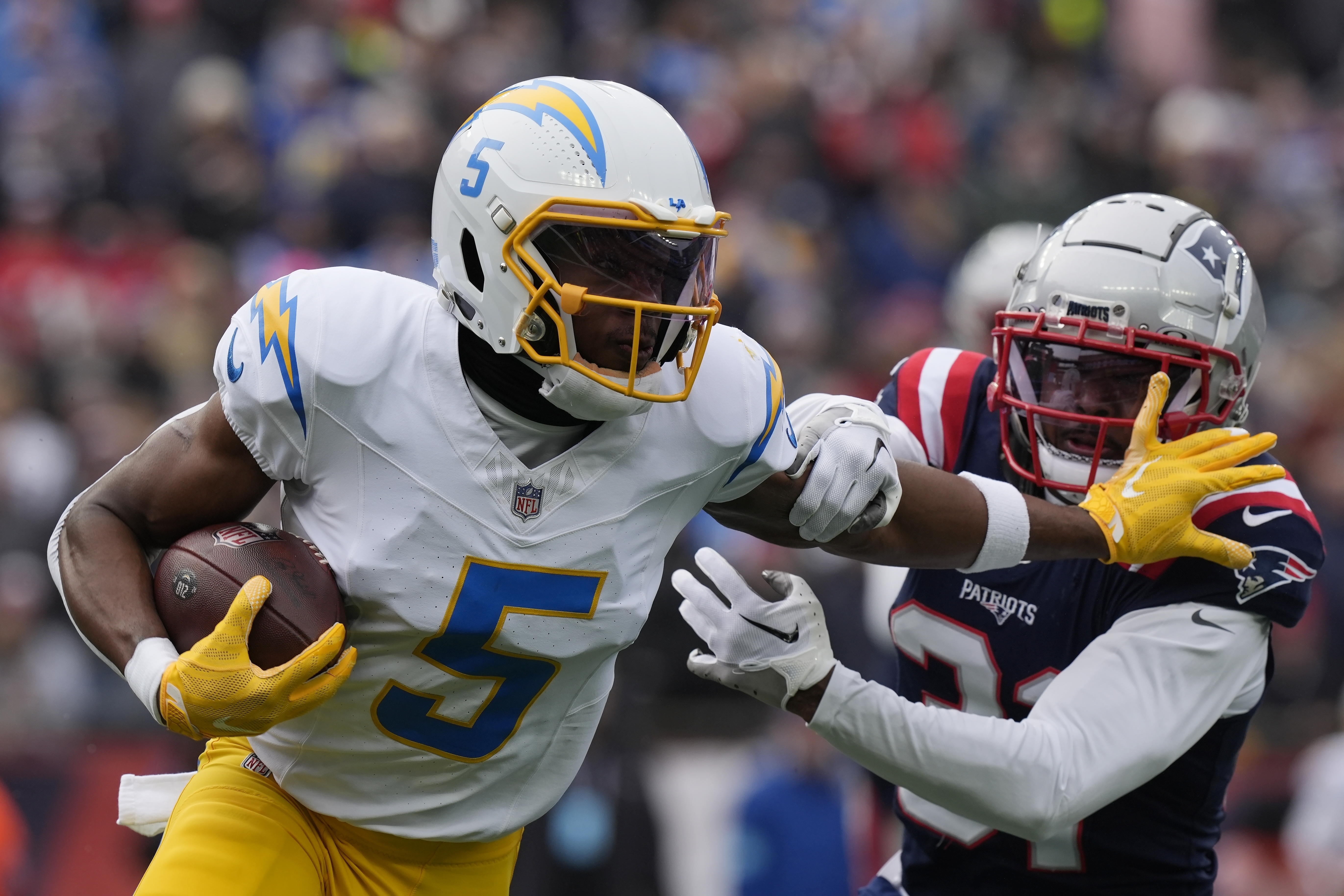 FILE - Los Angeles Chargers wide receiver Joshua Palmer (5) evades New England Patriots cornerback Jonathan Jones (31) during the first half of an NFL football game, Dec. 28, 2024, in Foxborough, Mass. 