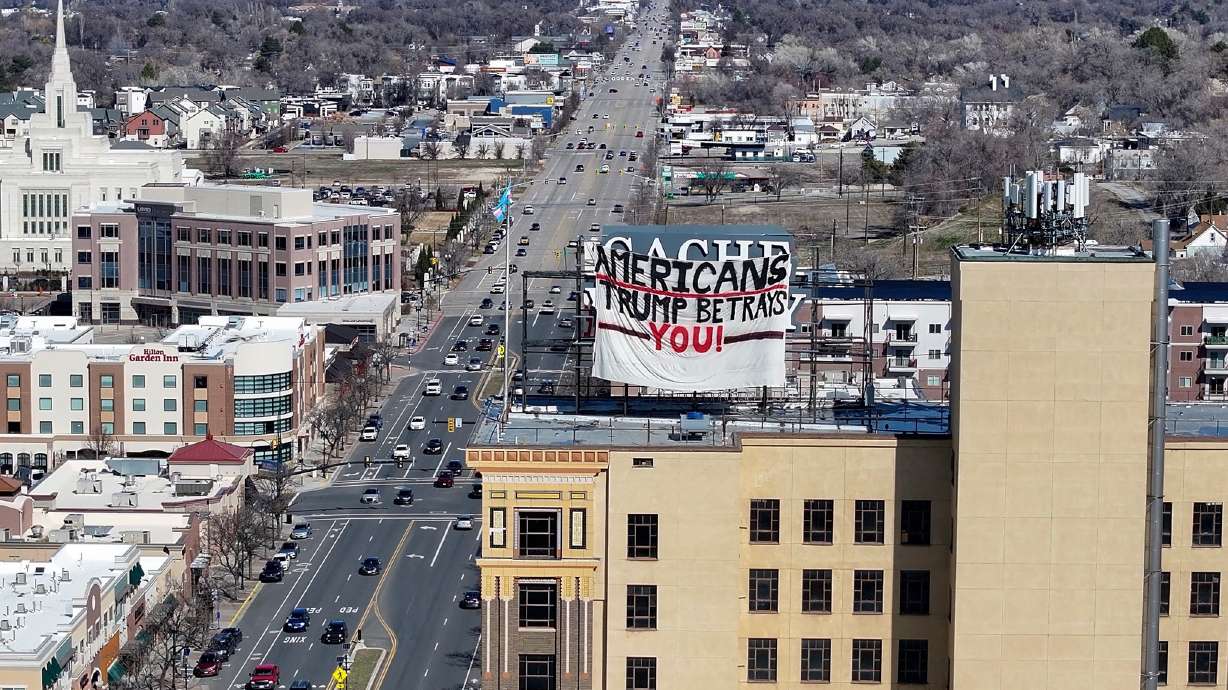 A photo from Saturday, March 8, 2025, showing a sign critical of President Donald Trump clandestinely placed atop the 13-story Cache Valley Bank building.