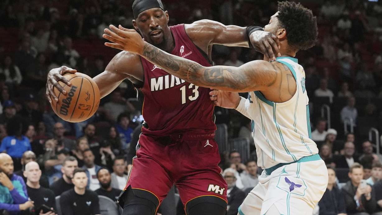 Miami Heat center Bam Adebayo (13) dribbles the ball as Charlotte Hornets forward Miles Bridges (0) defends during the first half of an NBA basketball game, Monday, March 10, 2025, in Miami.