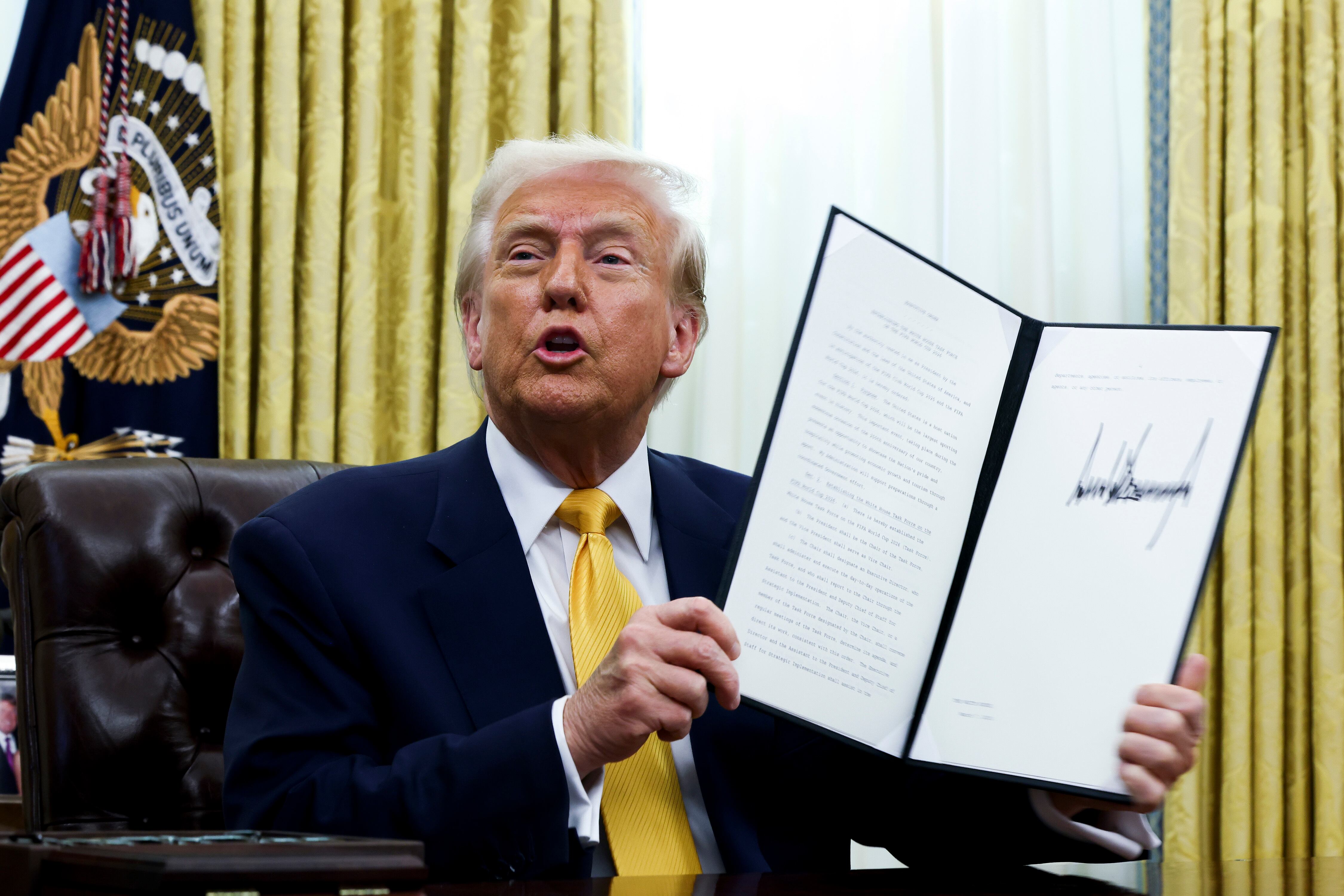 President Donald Trump holds a signed executive order as he speaks in the Oval Office of the White House in Washington, March 7. Trump has signed 83 executive orders since his first day office.