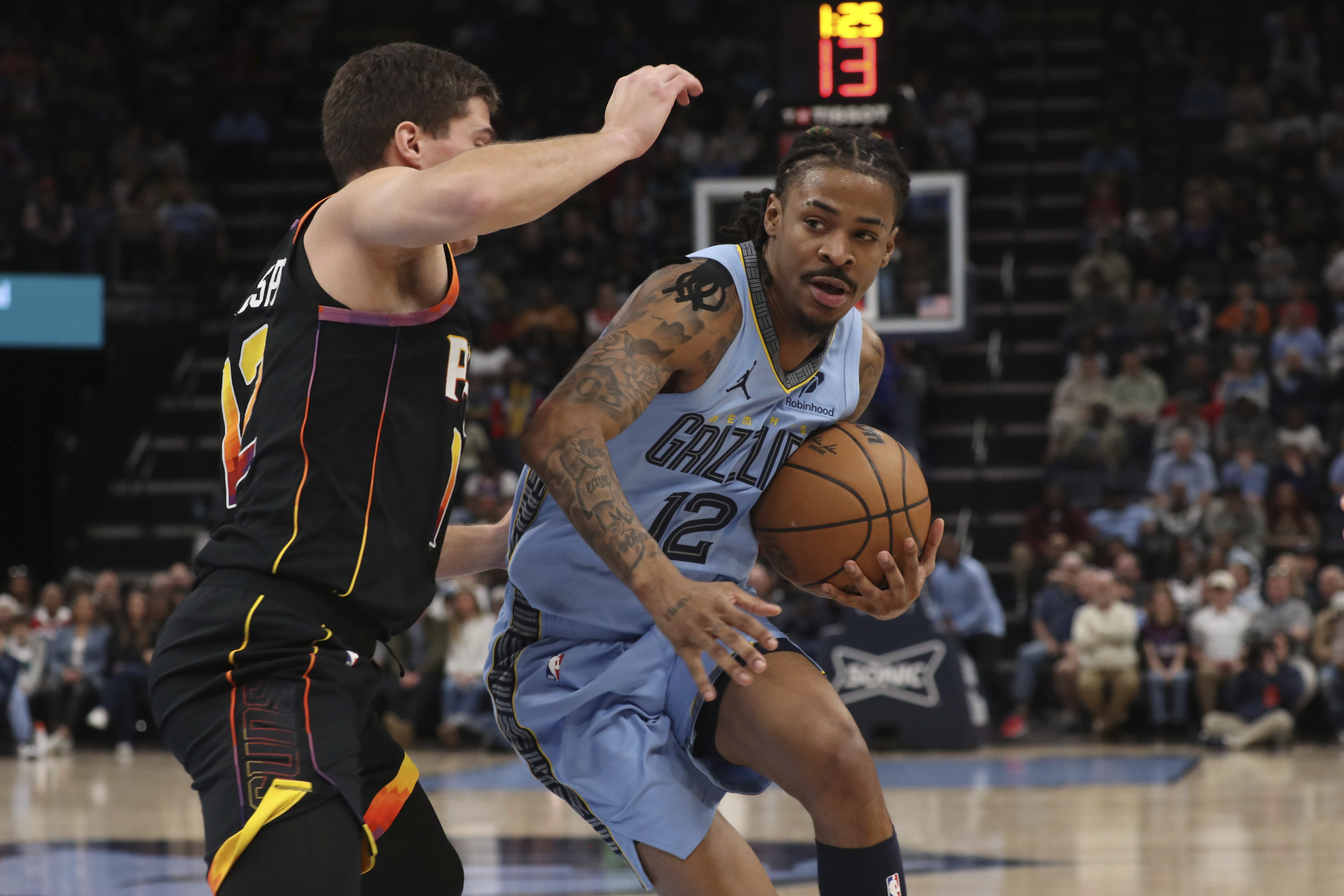 Phoenix Suns guard Collin Gillespie, left, defends against Memphis Grizzlies guard Ja Morant, right, in the first half of an NBA basketball game Monday, March 10, 2025, in Memphis, Tenn.