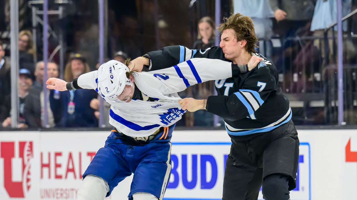 Utah Hockey Club defenseman Michael Kesselring (7) punches Toronto Maple Leafs defenseman Simon Benoit, left, in a fight during the second period of an NHL hockey game Monday, March 10, 2025, in Salt Lake City.
