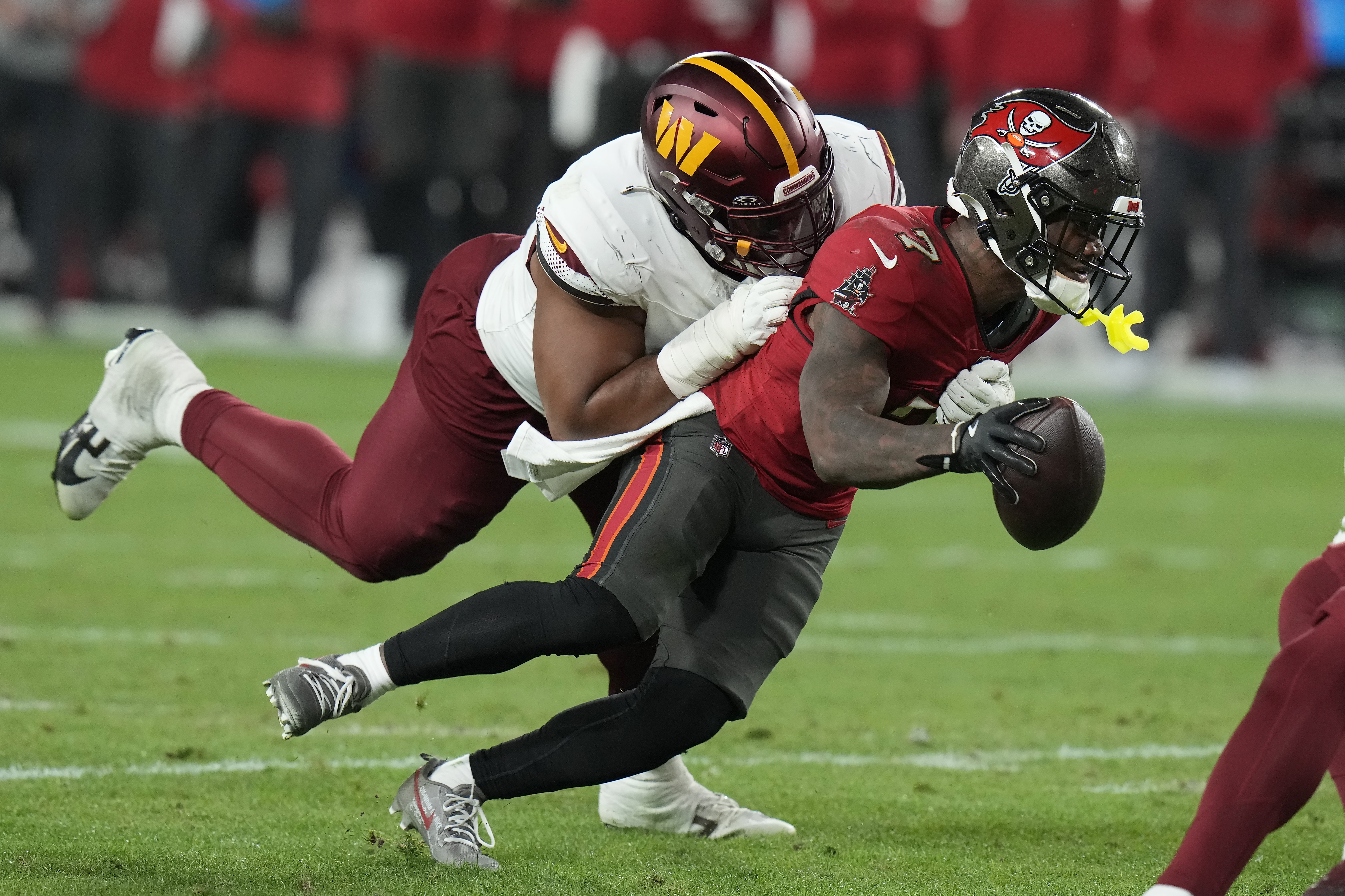 FILE- Tampa Bay Buccaneers running back Bucky Irving, right, runs against Washington Commanders defensive tackle Jonathan Allen during the second half of an NFL wild-card playoff football game in Tampa, Fla., Jan. 12, 2025. 